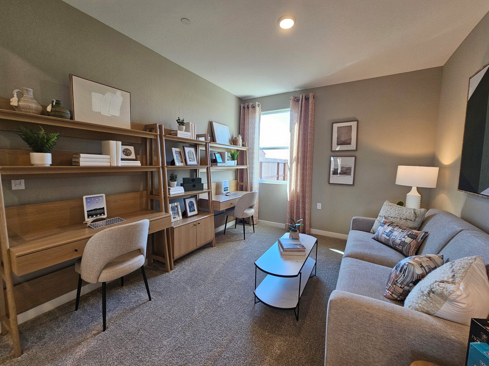 A living room with a desk and a couch.