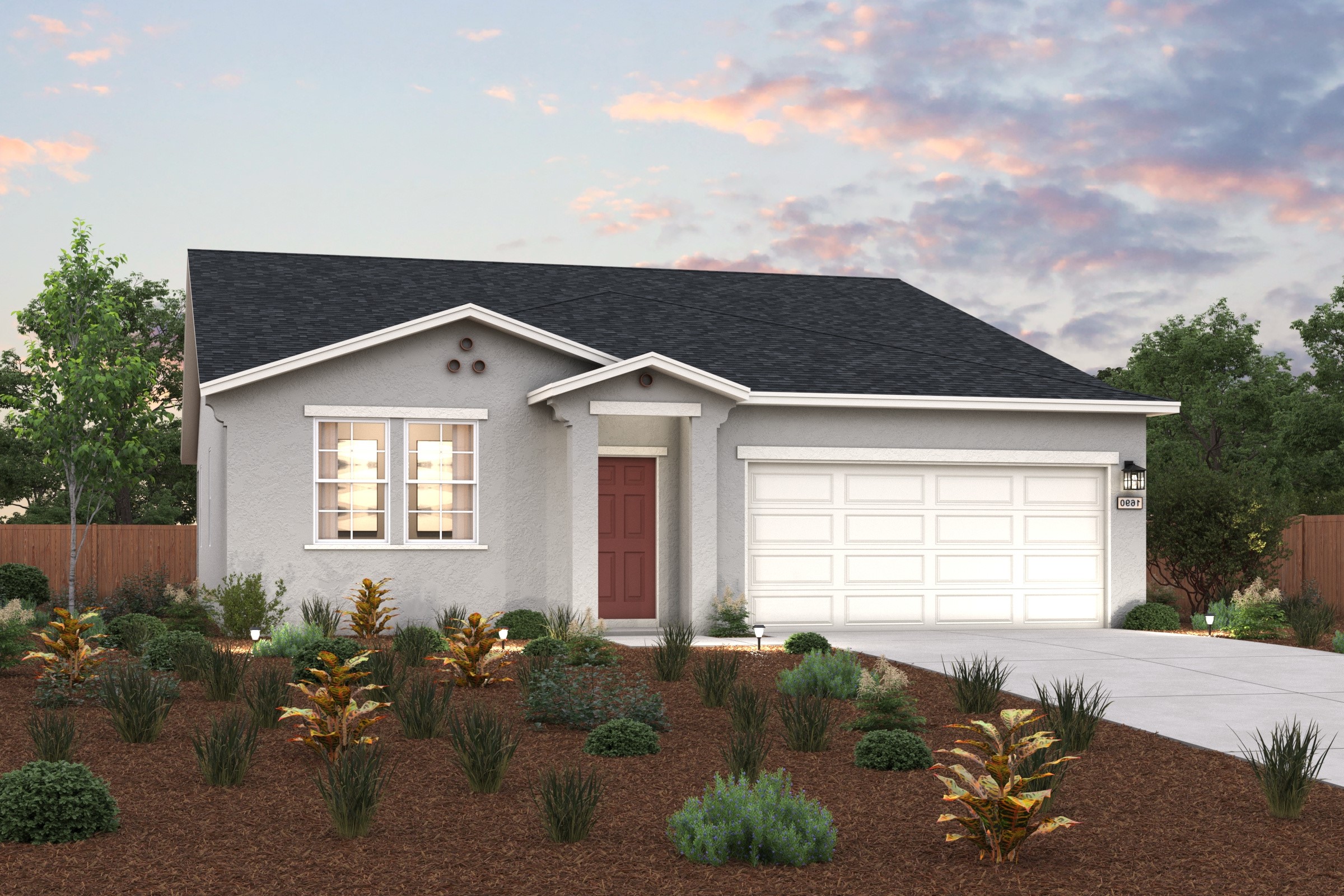 A house with a garage and bushes in front of it.