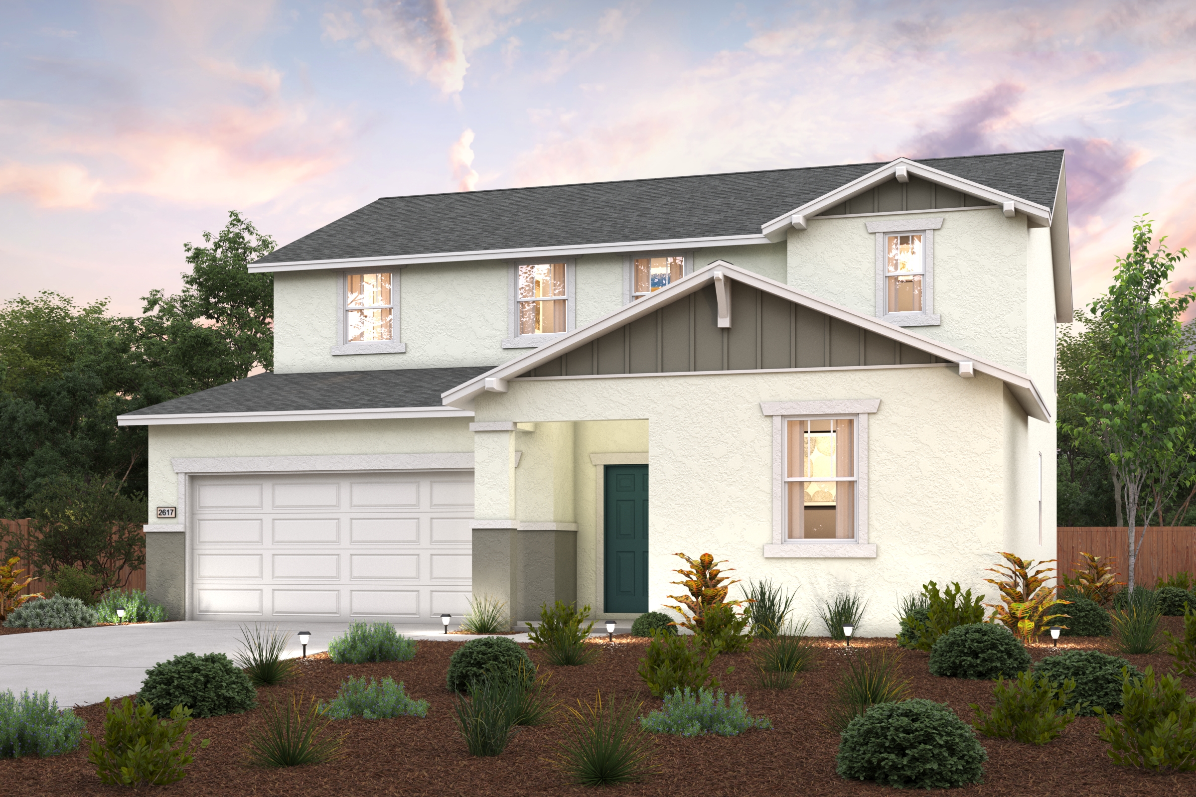 A house with a garage and bushes in front of it.