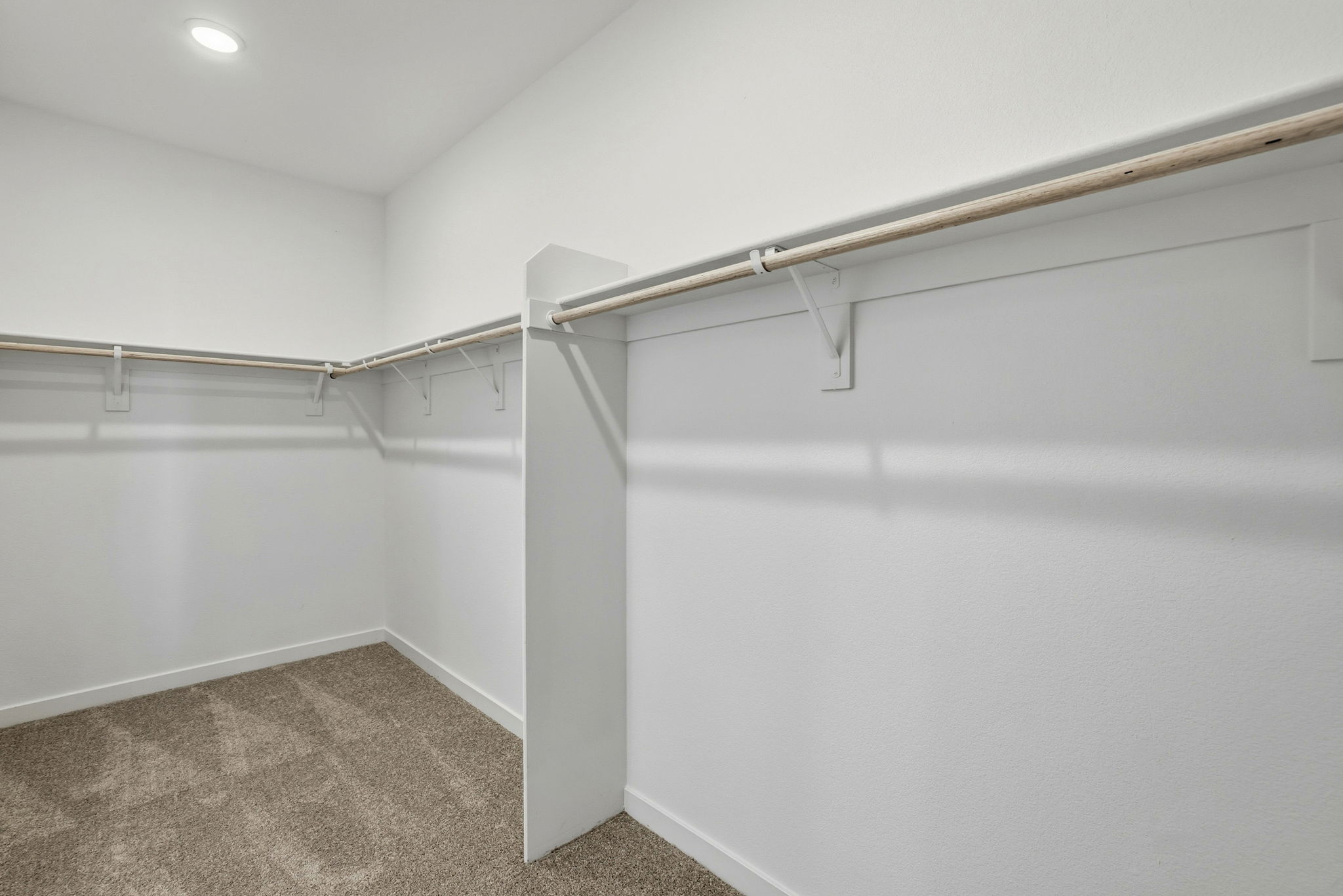 A white wall with a metal bar.