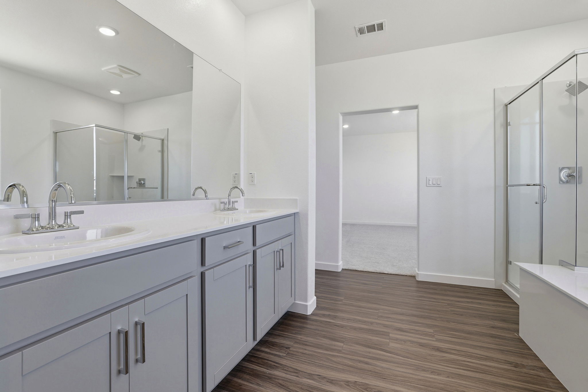 A bathroom with white cabinets.