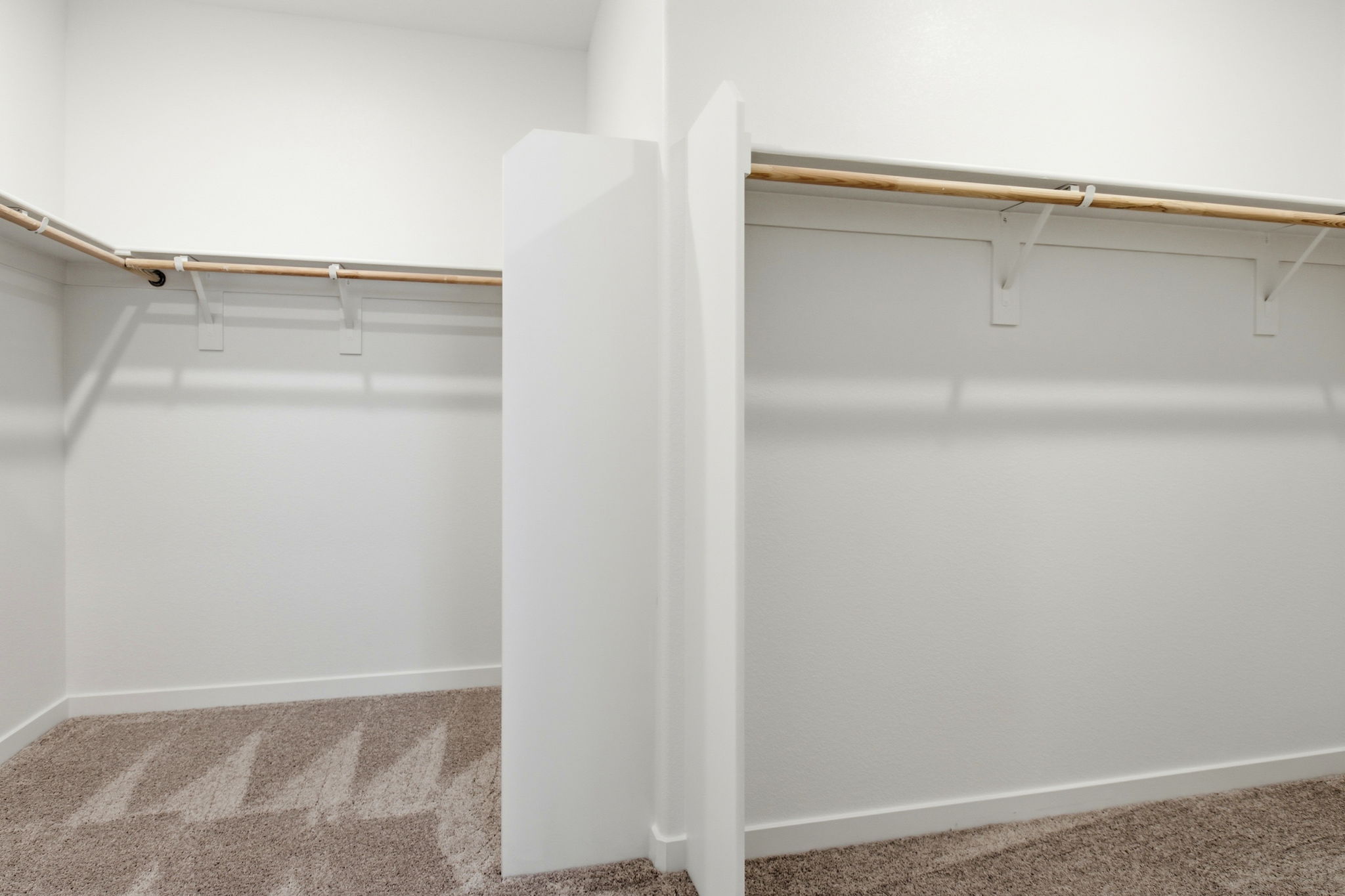 A white wall with a metal bar.