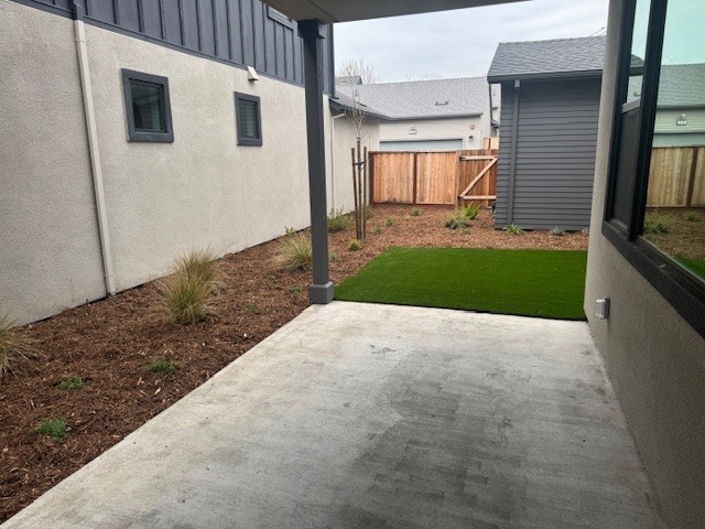 A backyard with a fence and a yard.