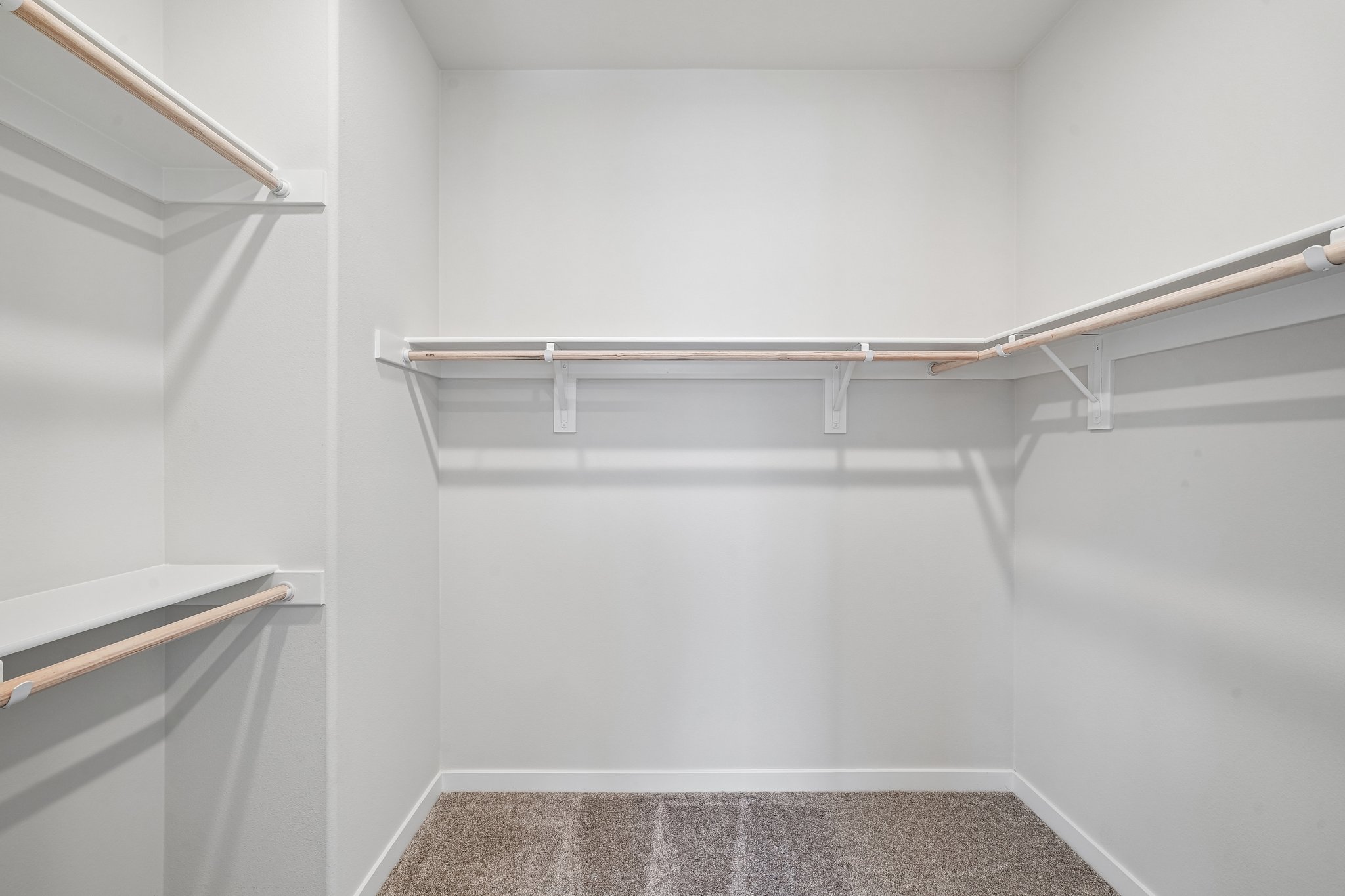 A white tiled room with a metal railing.