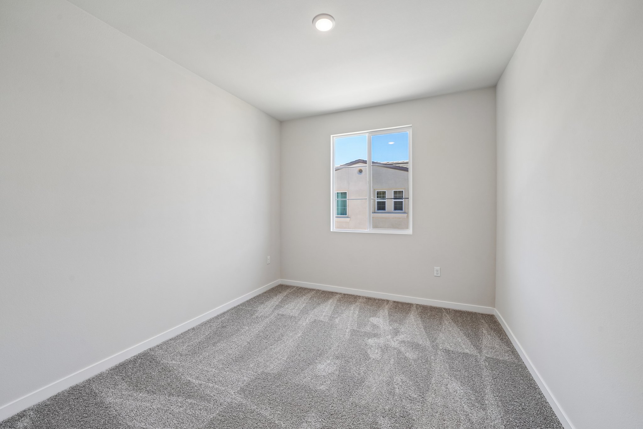 A room with a window and a carpet.