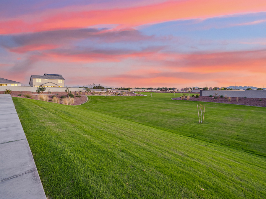 A grassy field with buildings in the background.