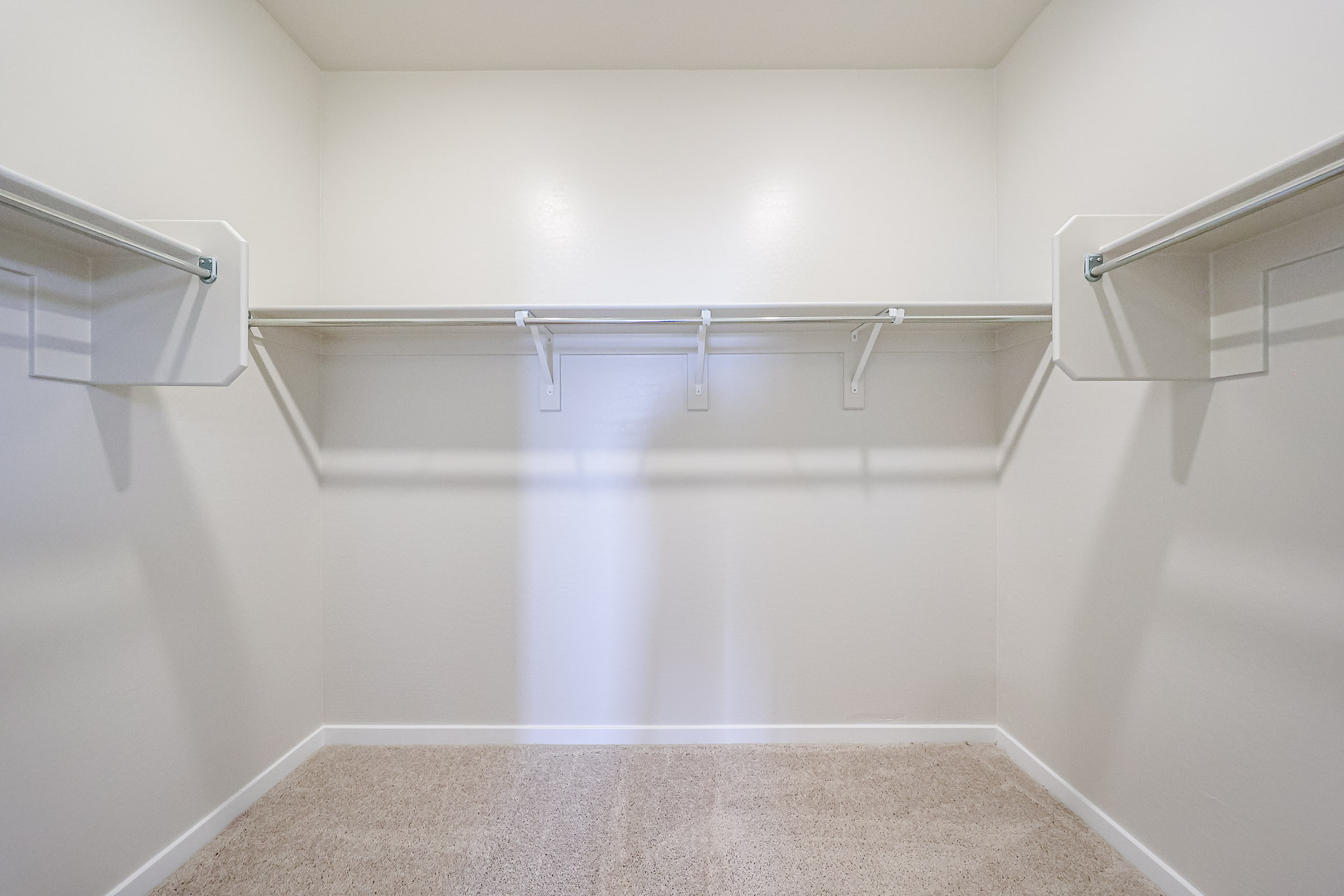 A white wall with a metal bar.