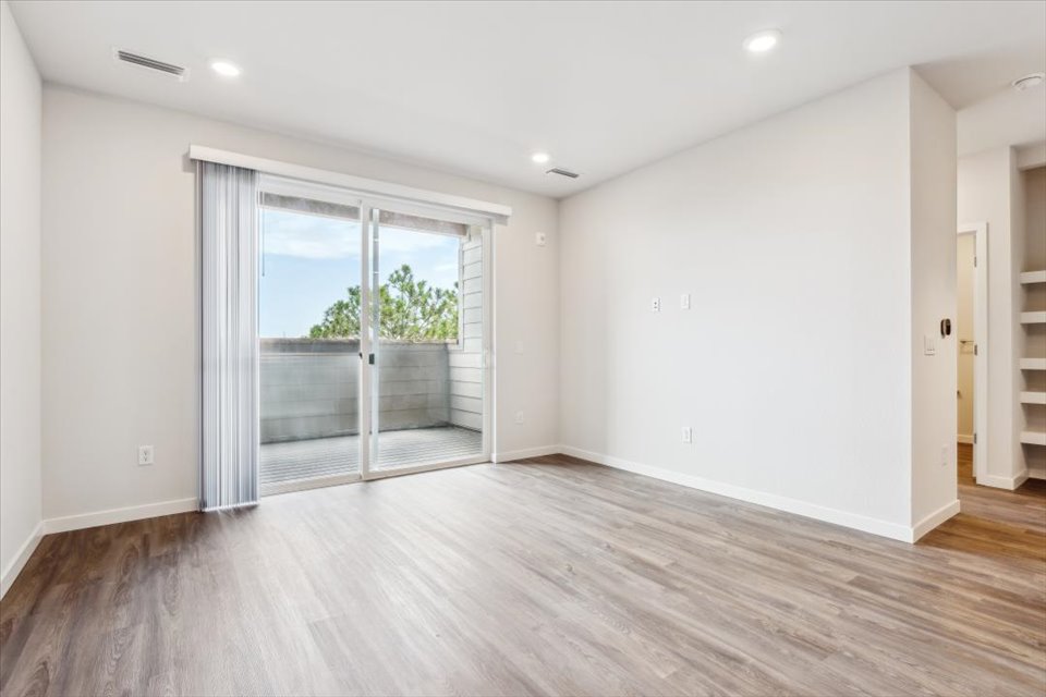 A room with a wood floor and a glass door.