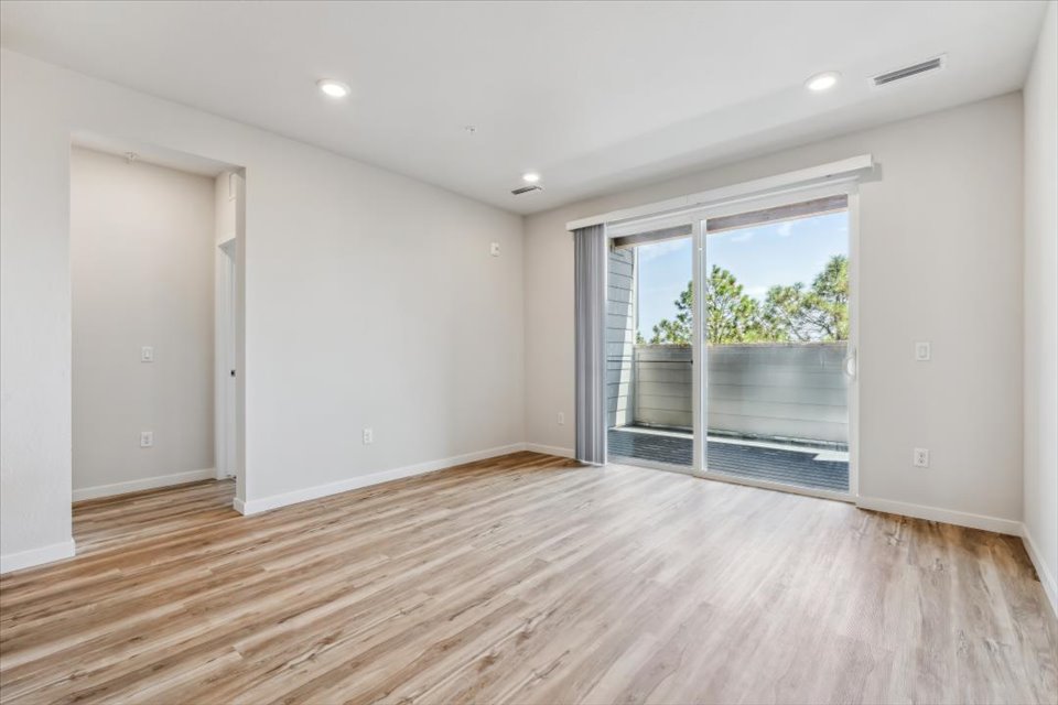 A room with a wood floor and a wood floor with a window.