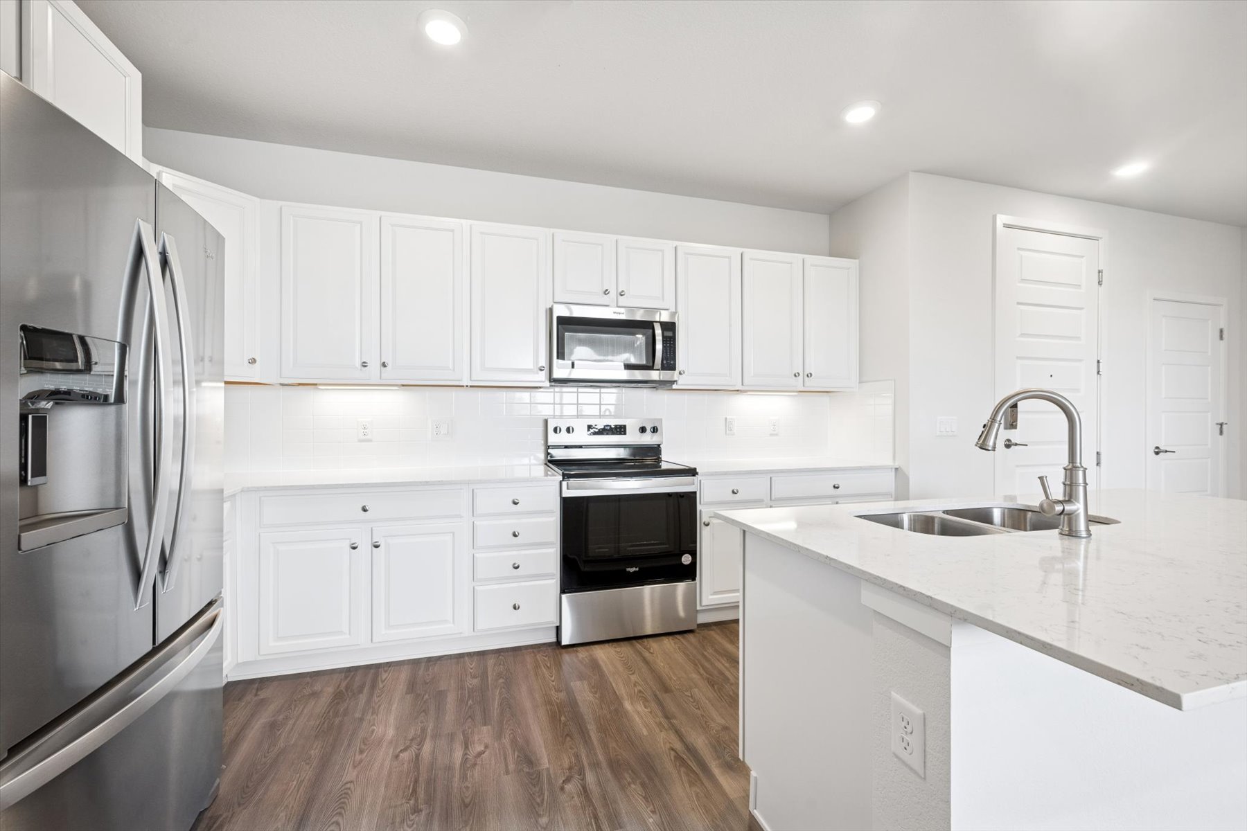 A kitchen with white cabinets.