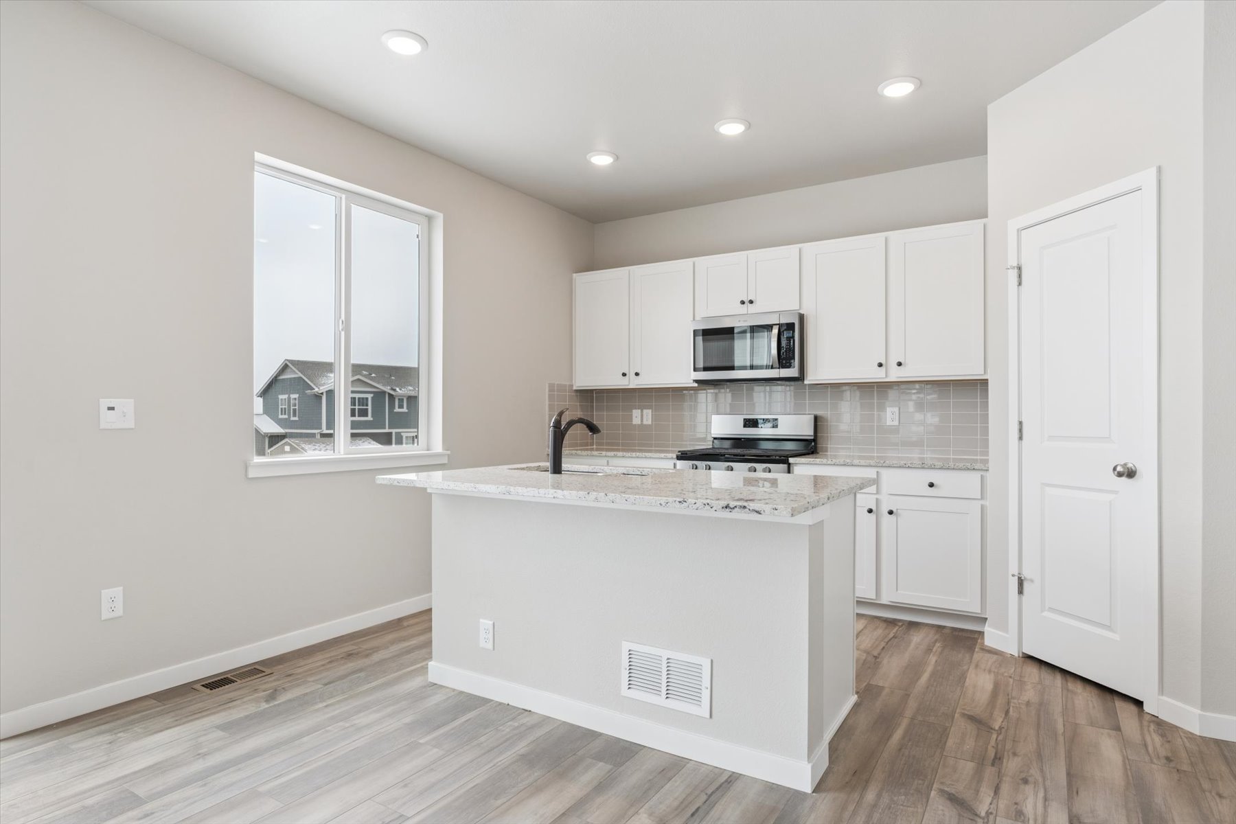 A kitchen with white cabinets.