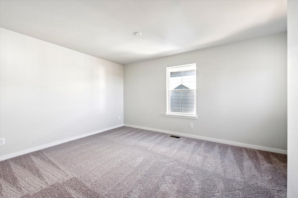 A room with a window and a carpet.