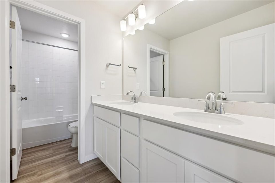 A bathroom with a tub sink and toilet.