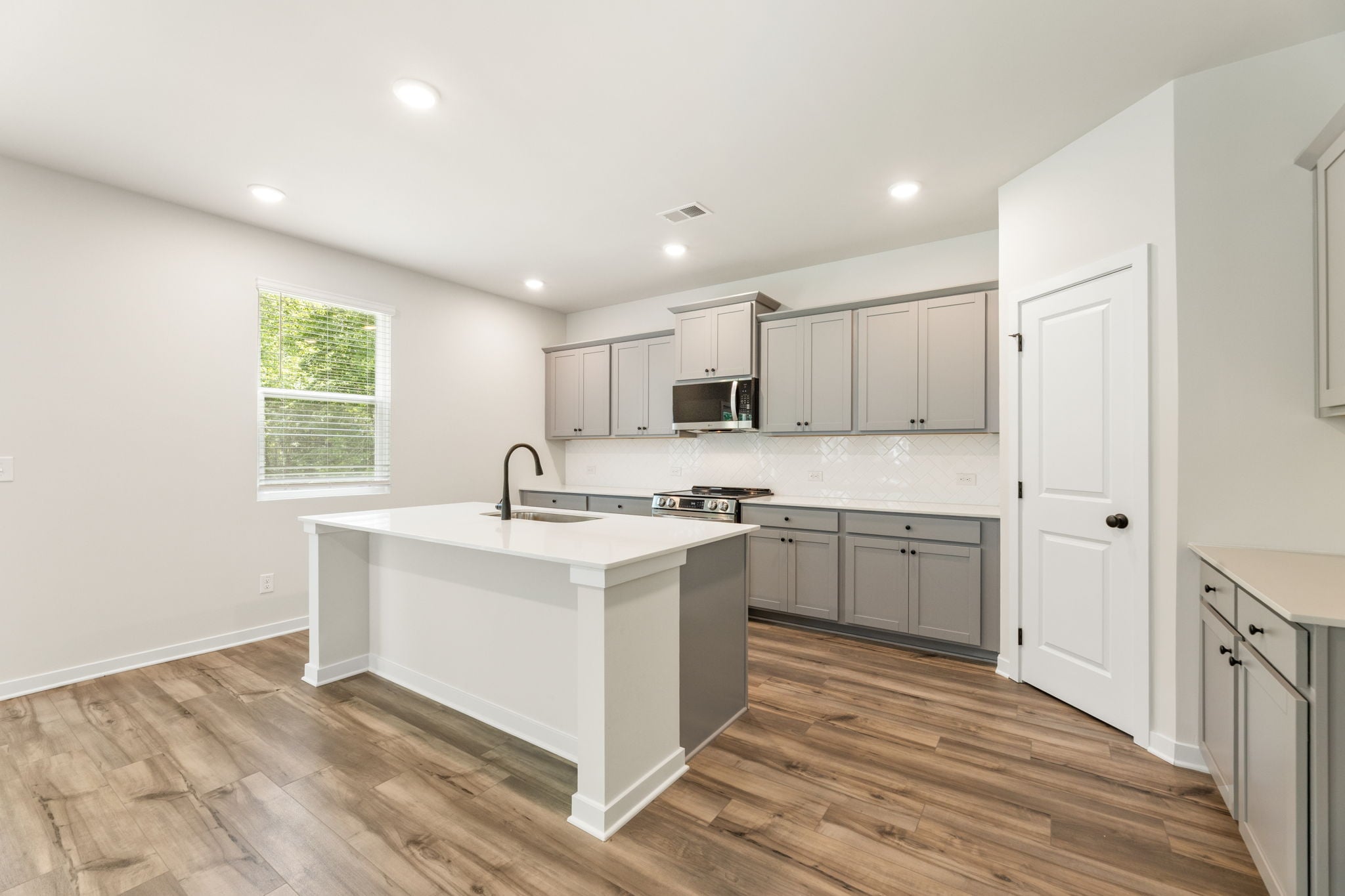 A kitchen with white cabinets.