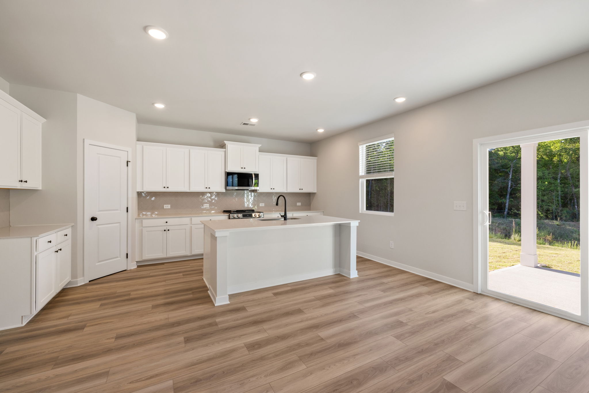 A kitchen with white cabinets.