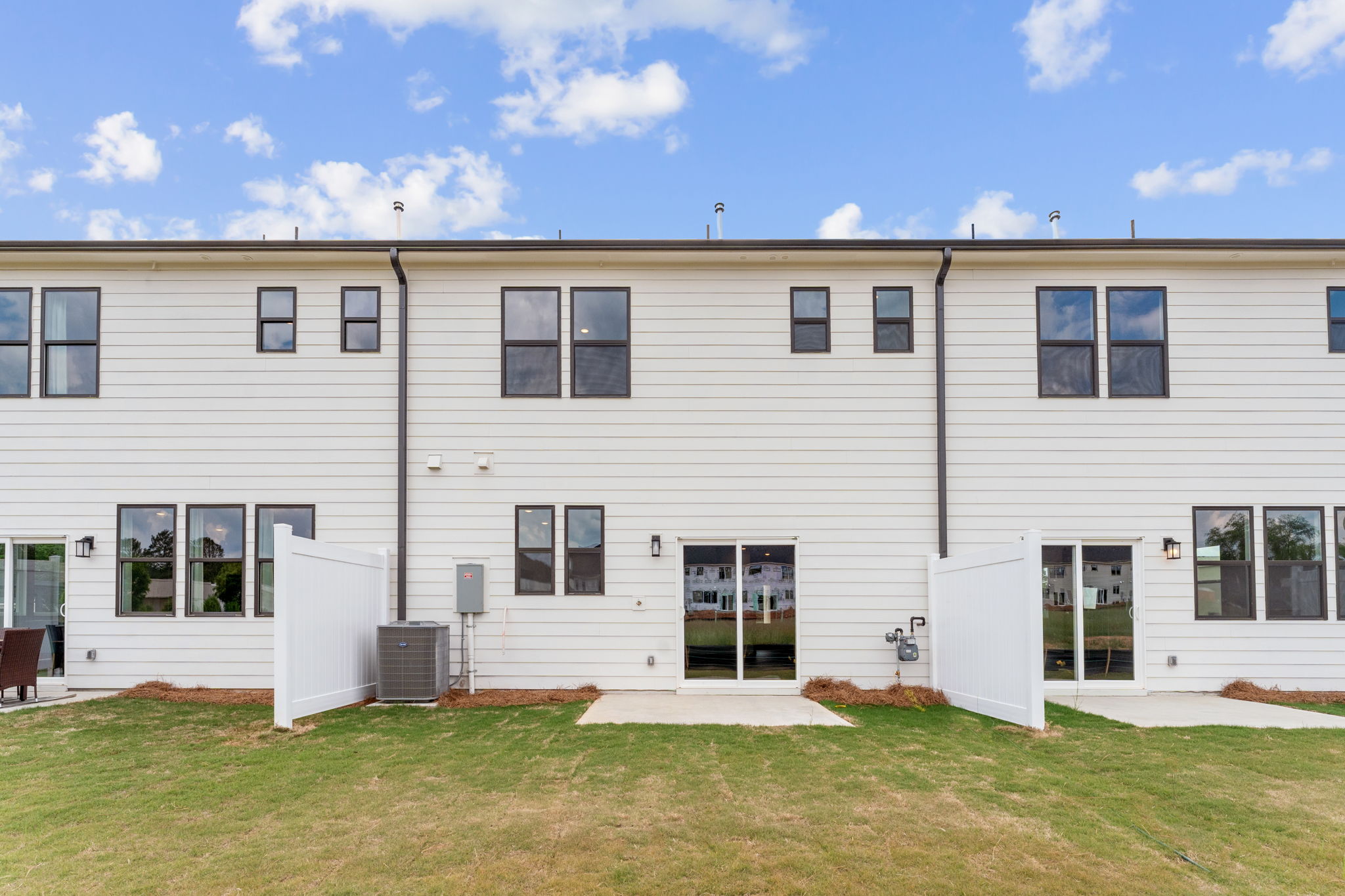 A white building with a lawn in front of it.