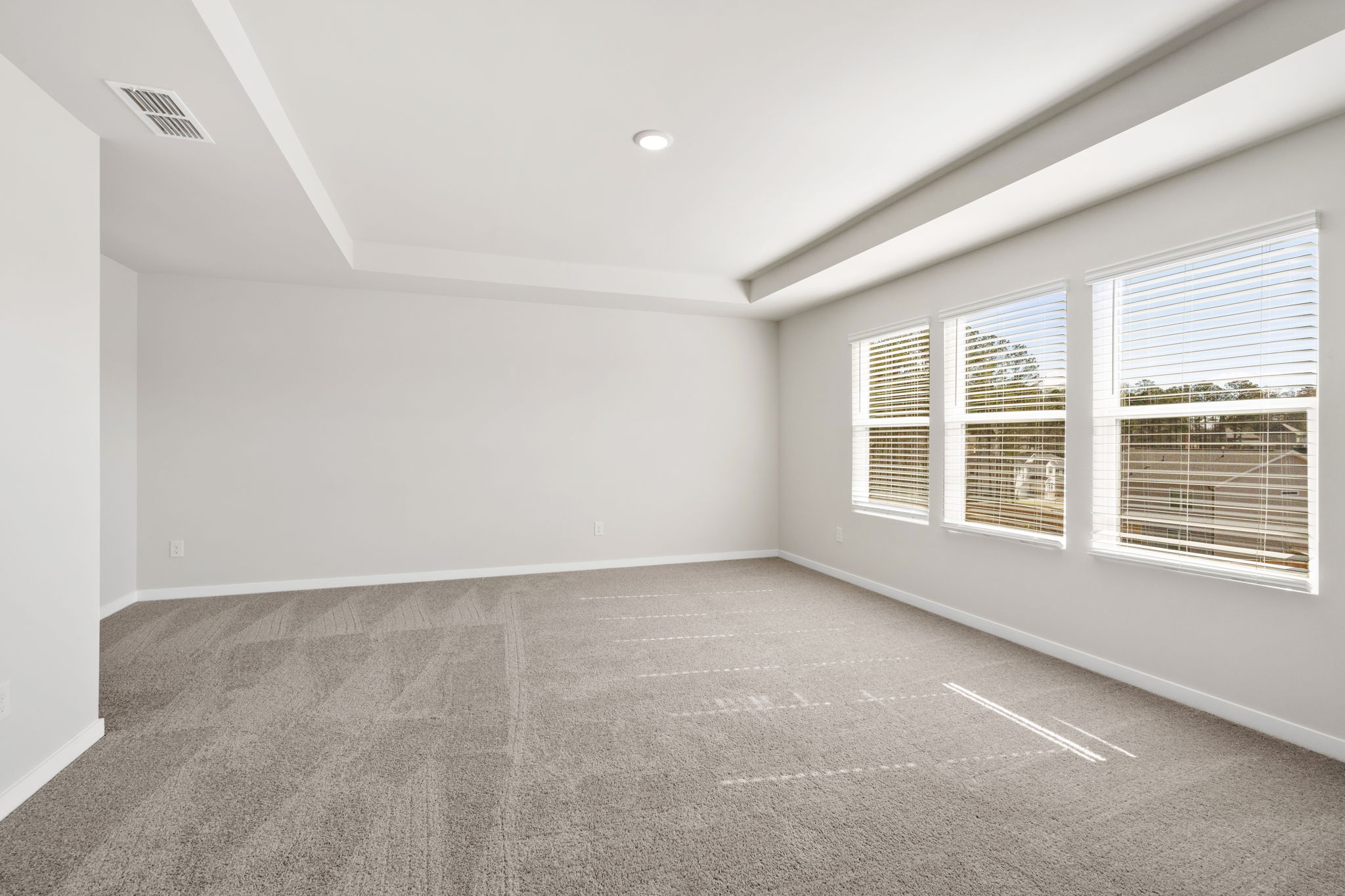 A room with a carpet and windows.