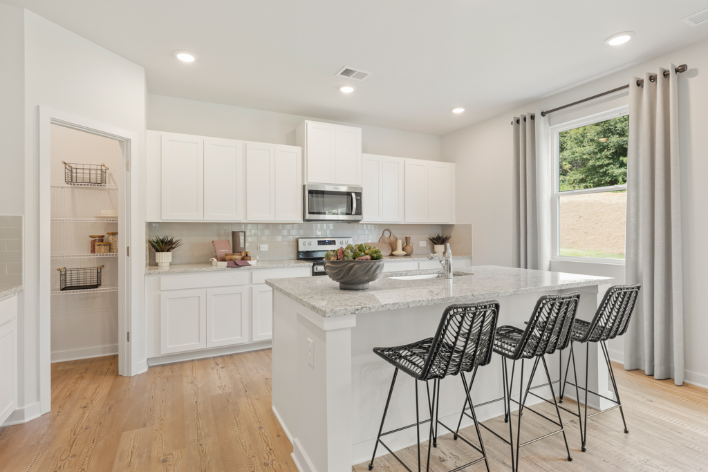 A kitchen with white cabinets.