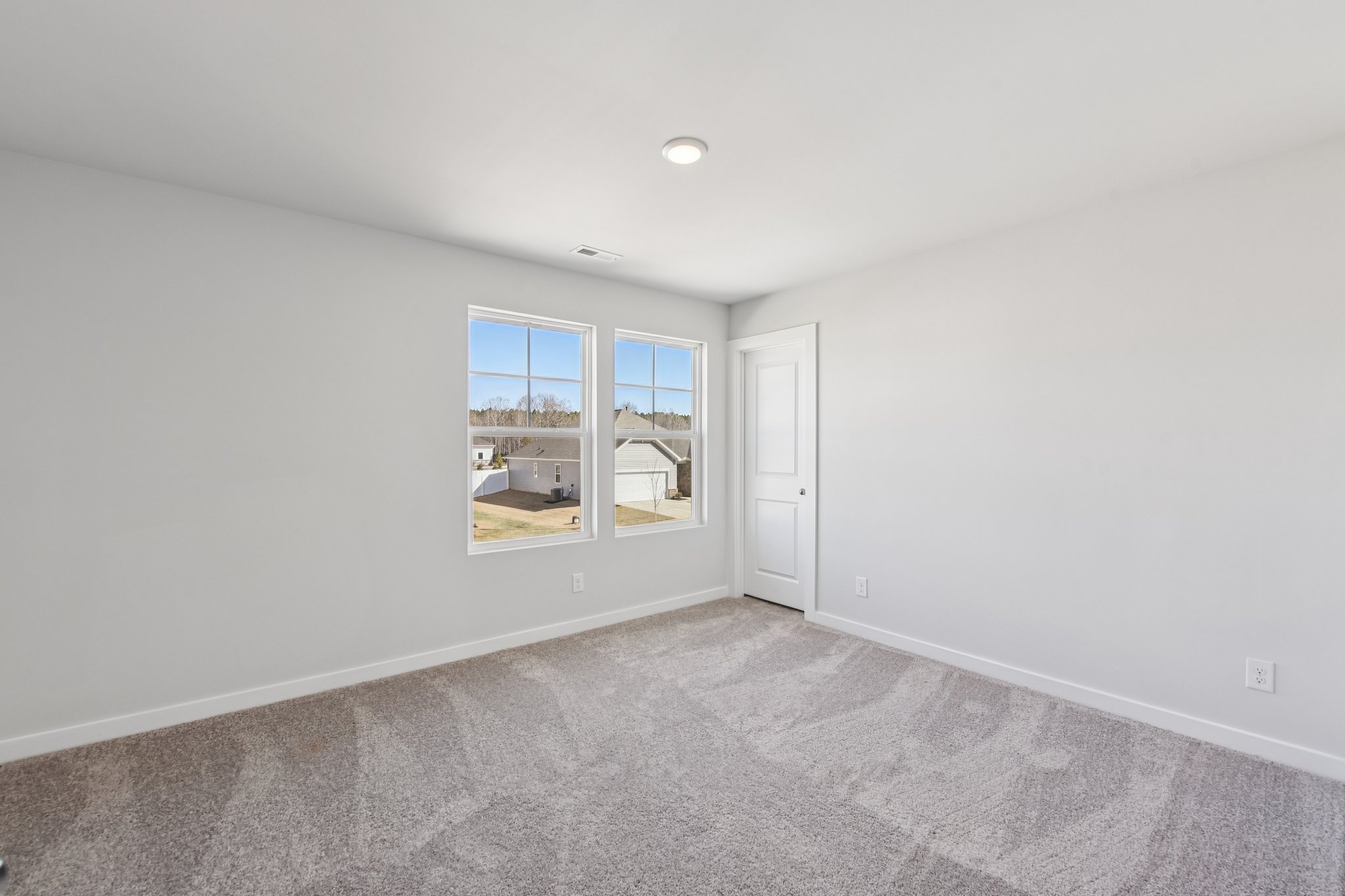 A room with a window and a carpet.