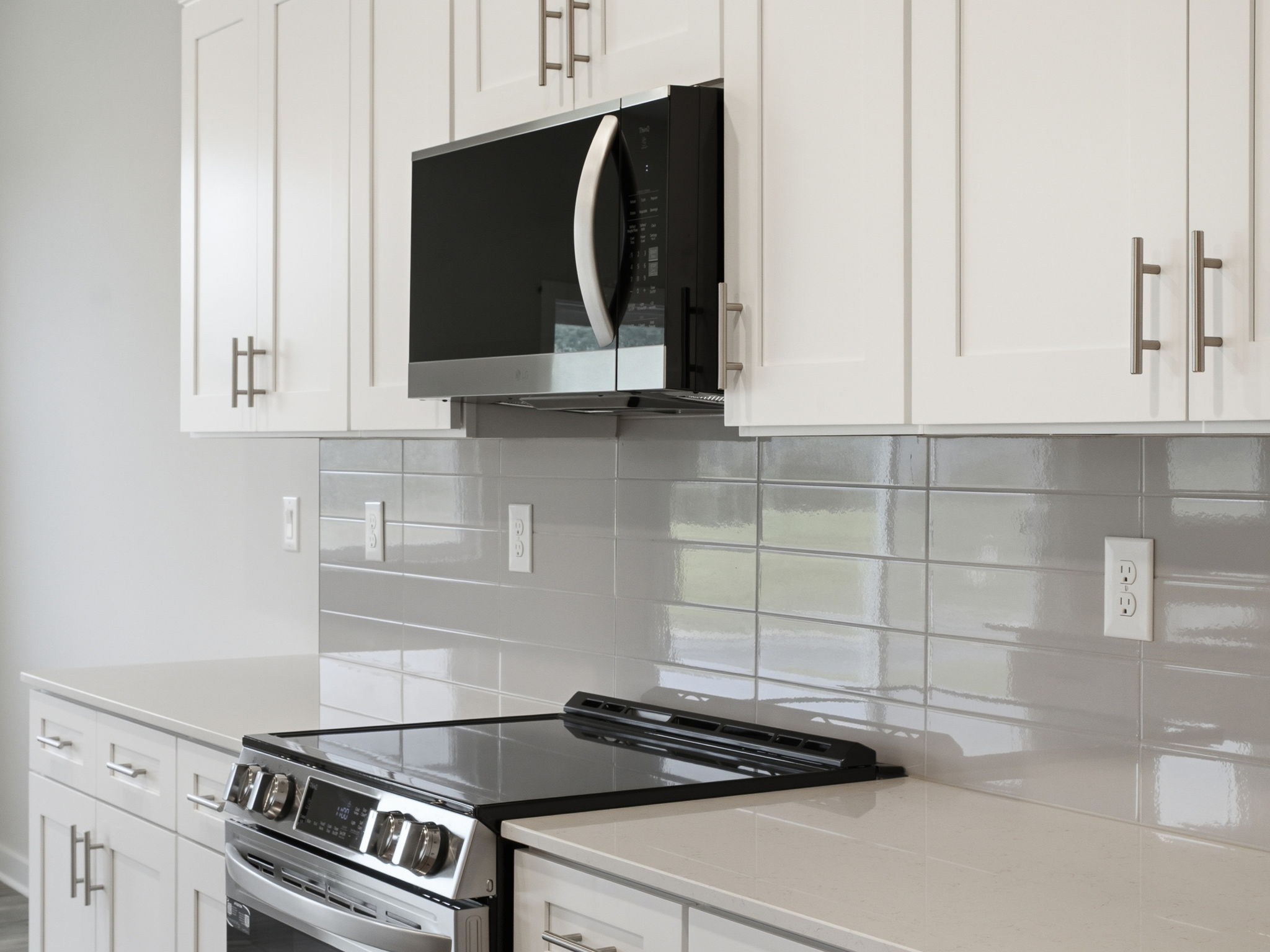 A kitchen with white cabinets.