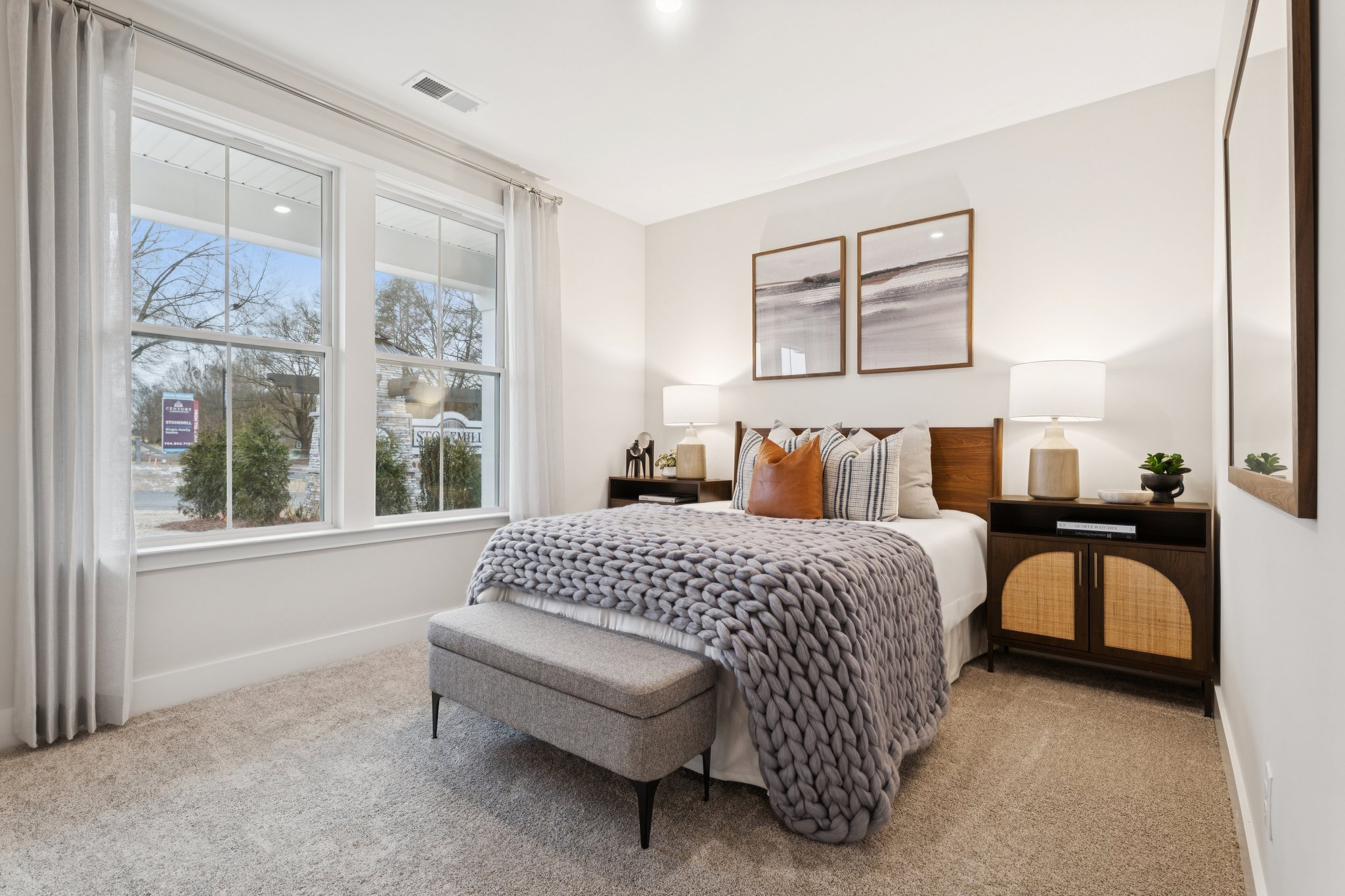 A bedroom with a bed and a bench.