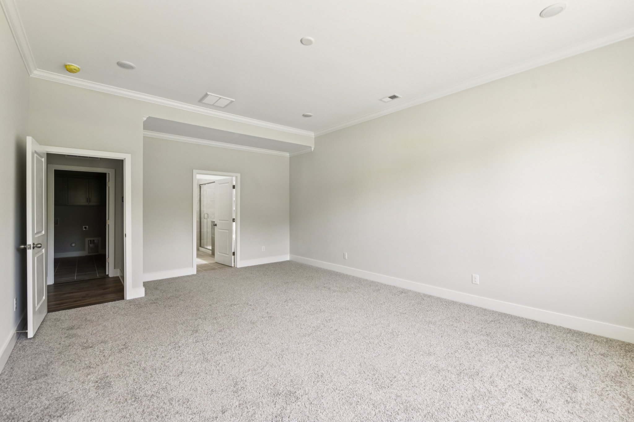 A room with a carpet and a door.