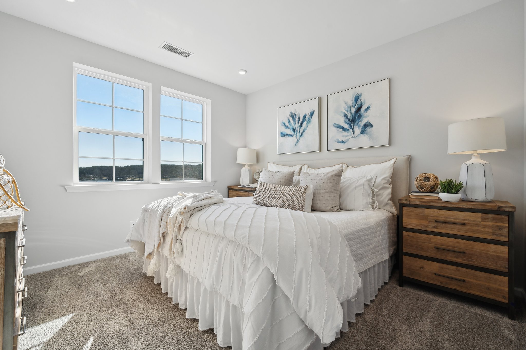 A bedroom with a bed and lamps.