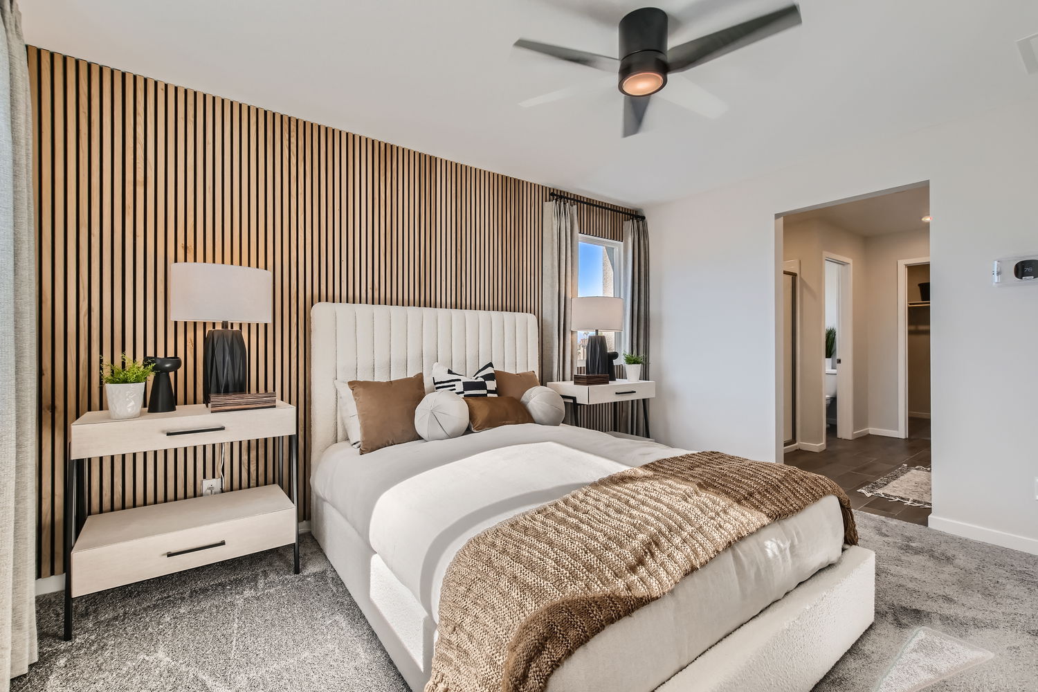 A bedroom with a bed and a fan.