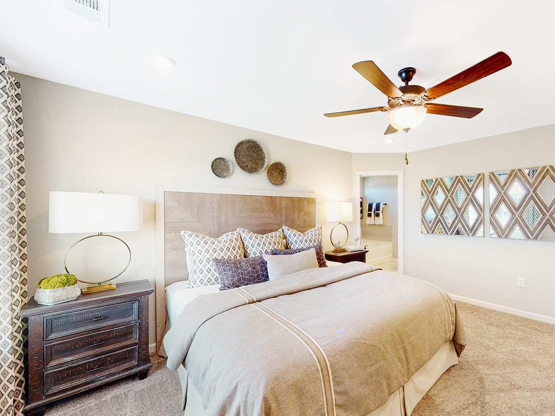 A bedroom with a bed and a fan.