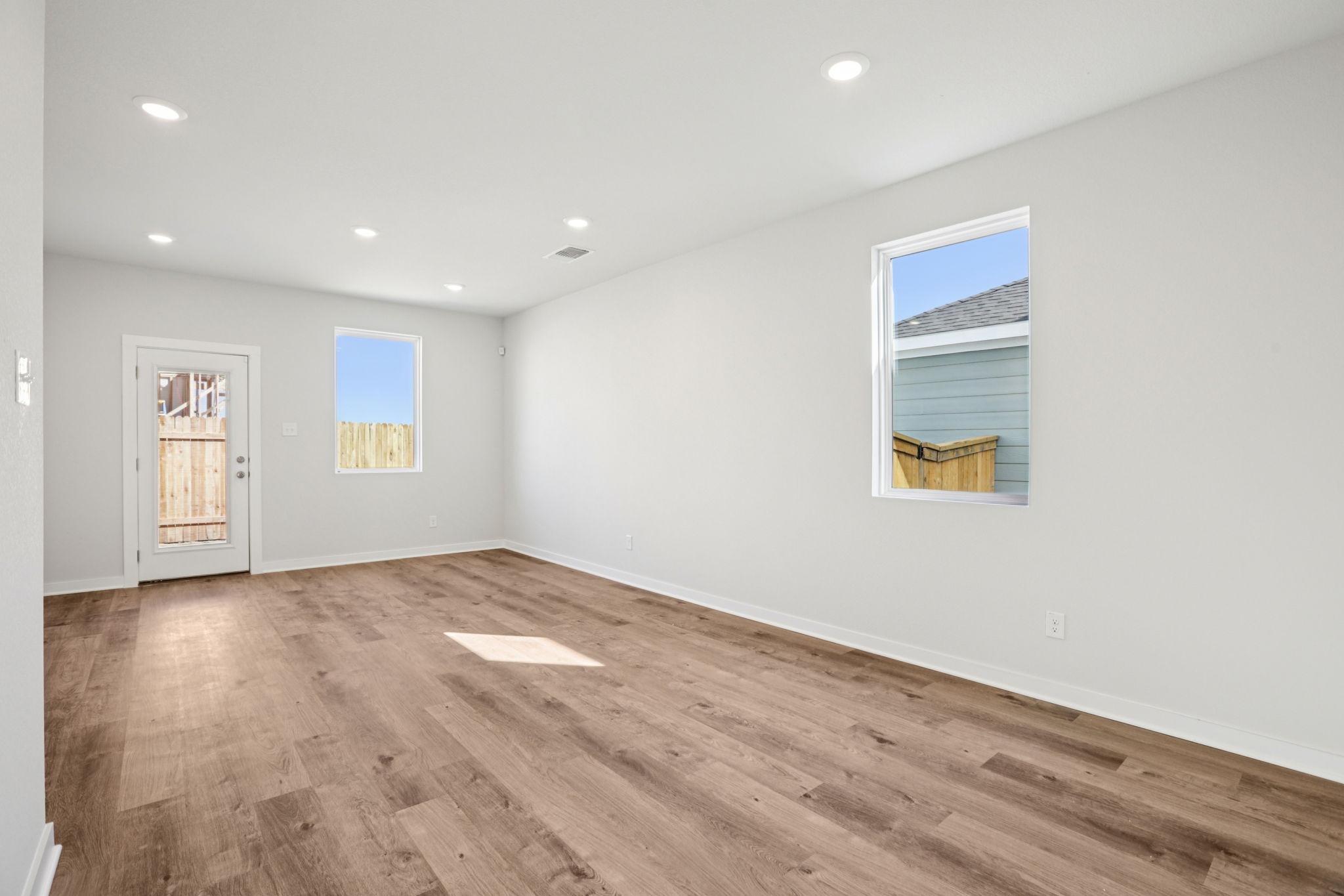 A room with a wood floor and a wood floor with a window.