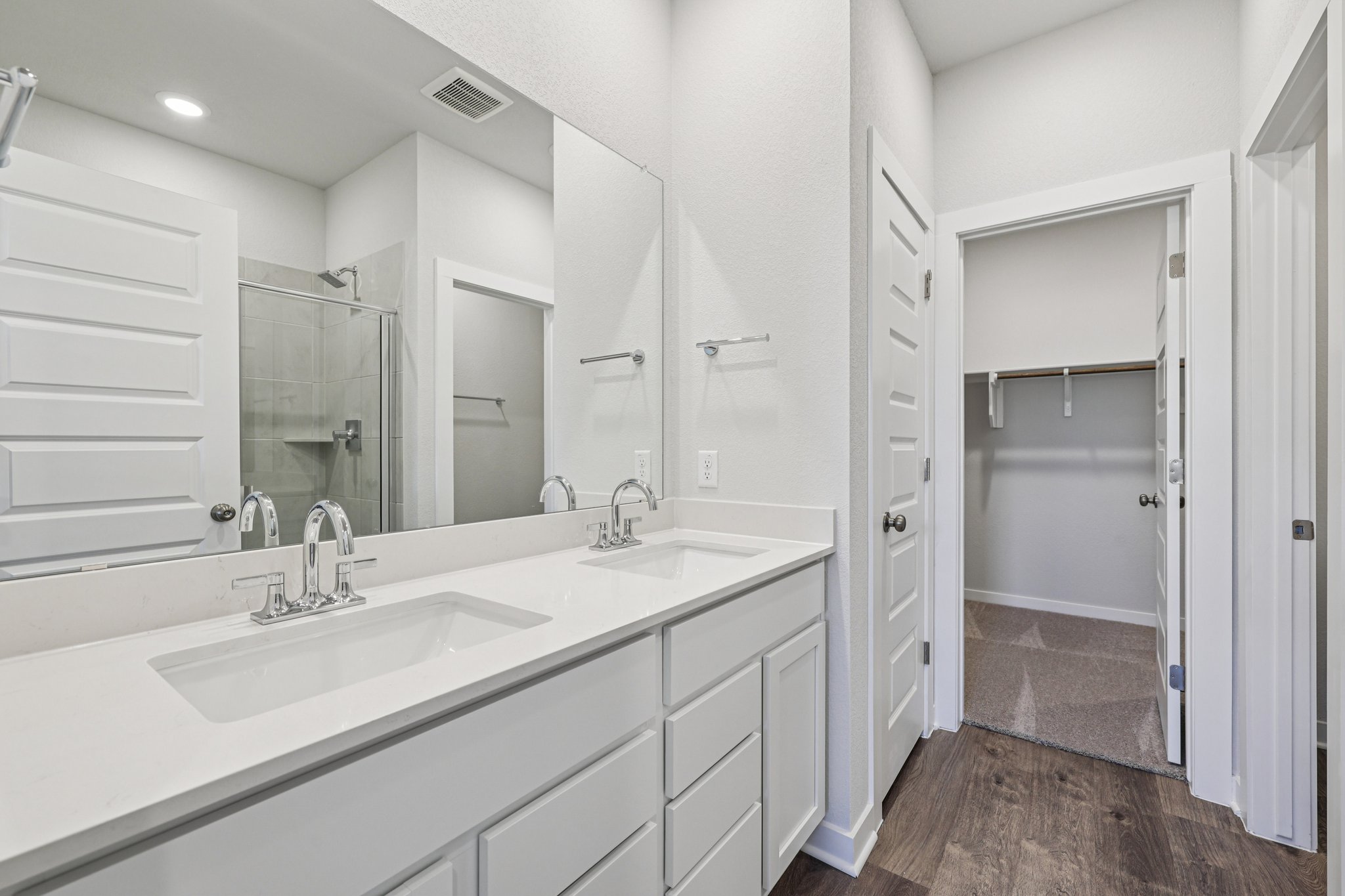 A bathroom with white cabinets.