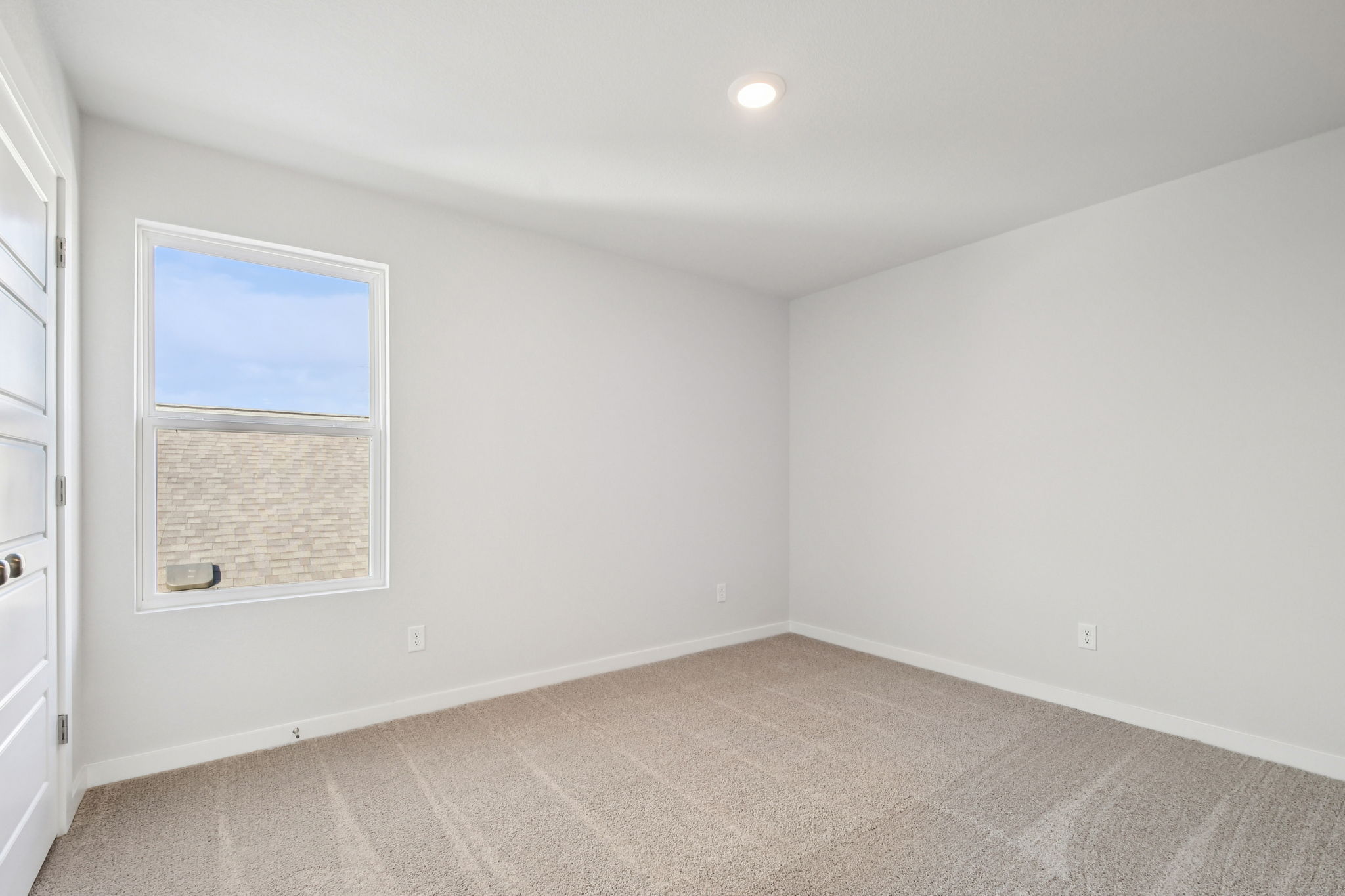 A room with a window and a carpet.