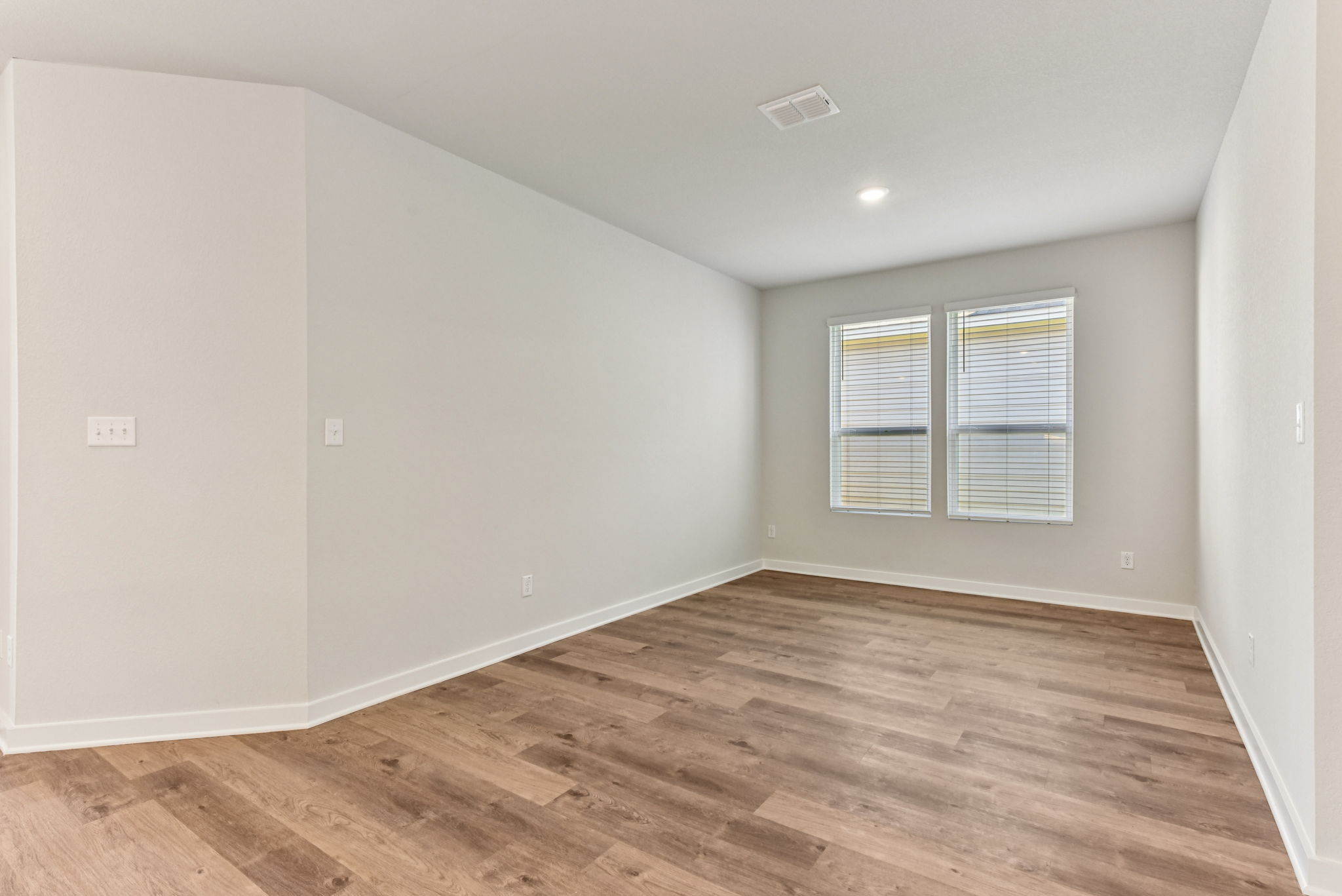 A room with a wood floor and a window.