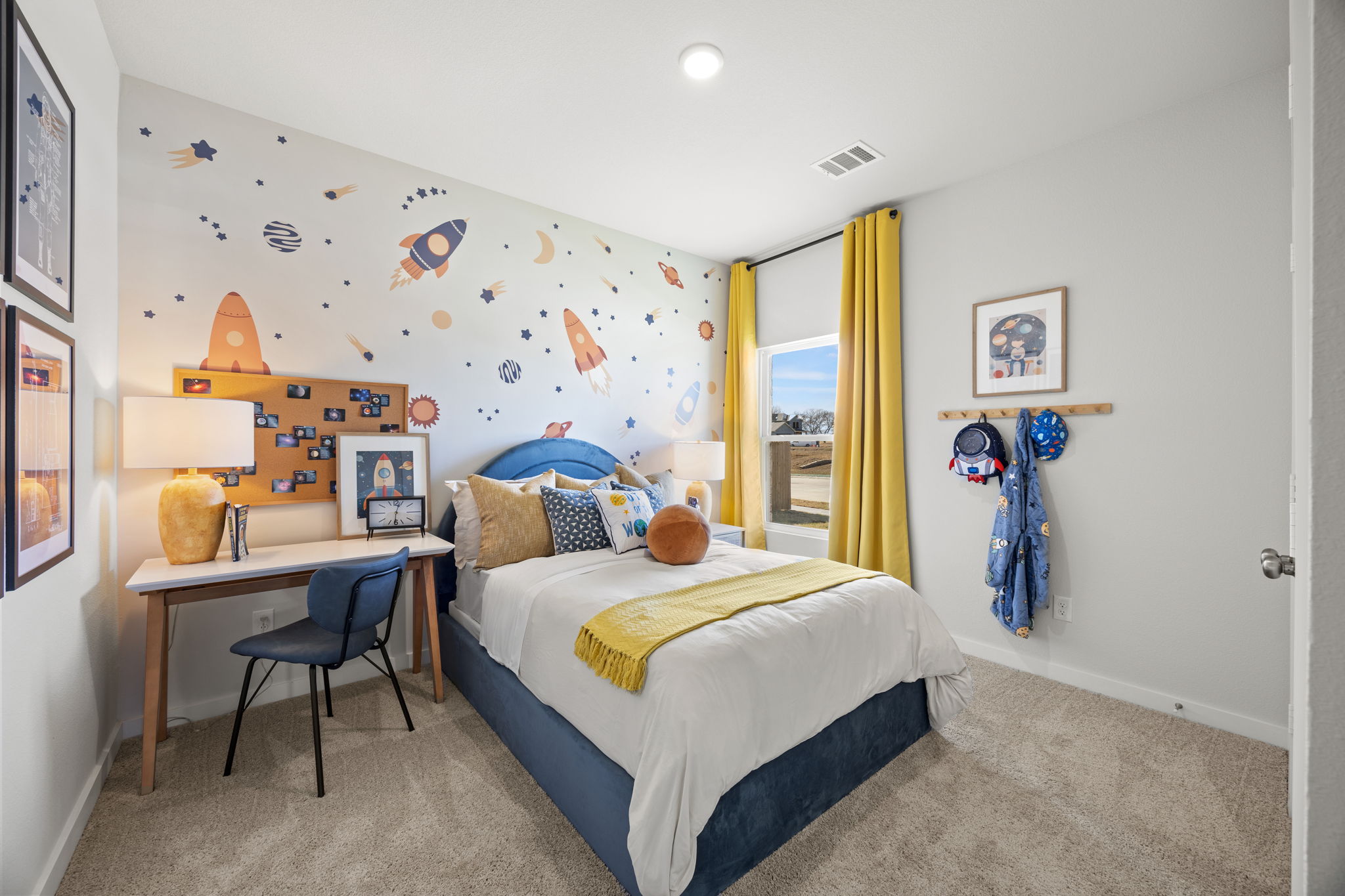 A bedroom with a bed desk and a chair.