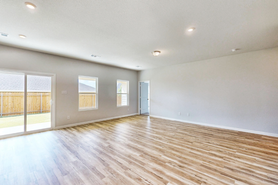 A room with a wood floor and windows.