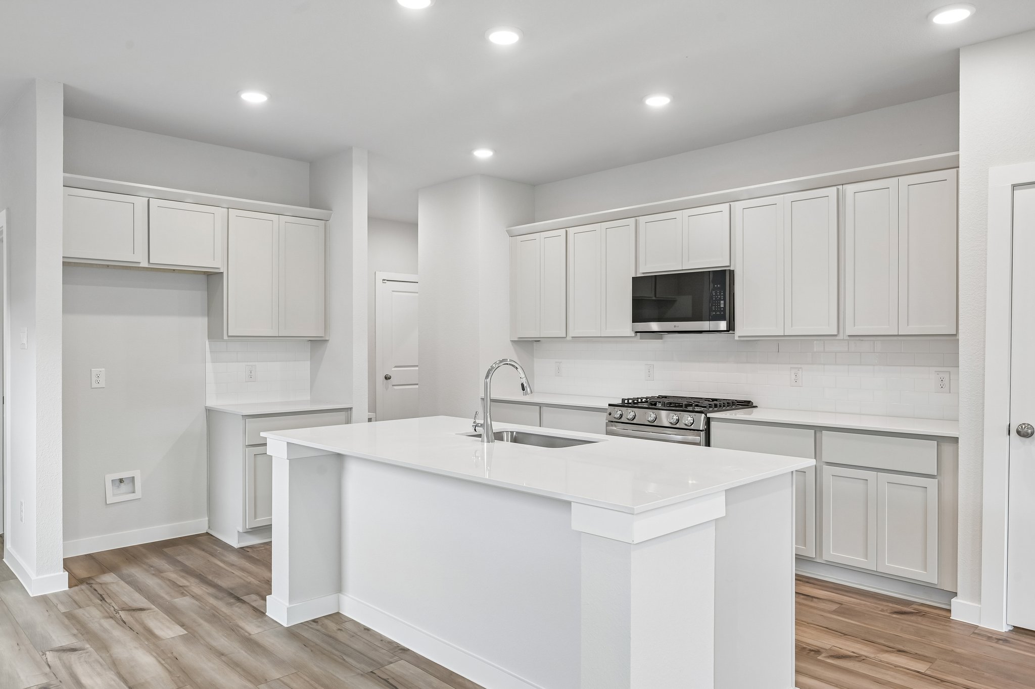 A kitchen with white cabinets.