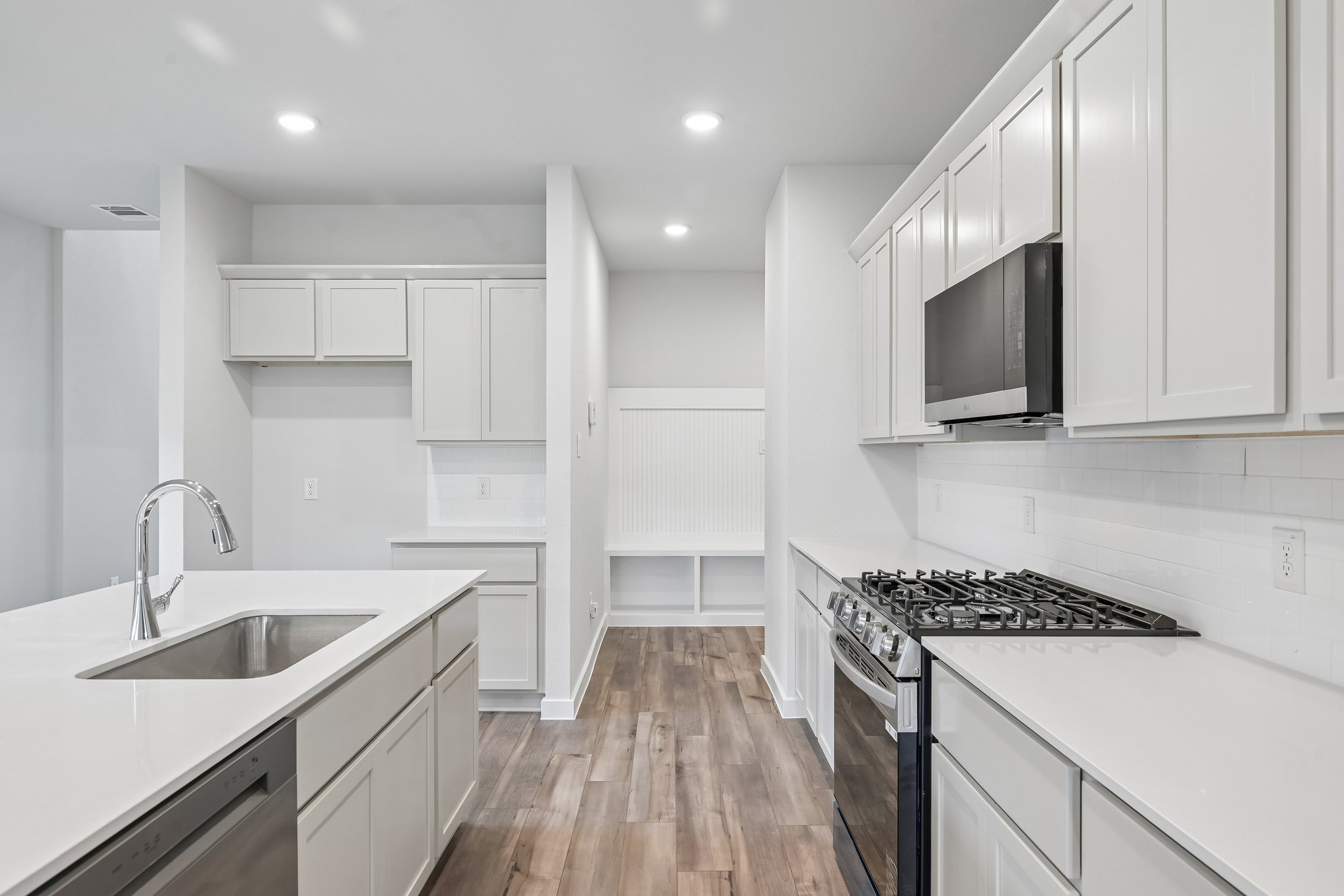 A kitchen with white cabinets.