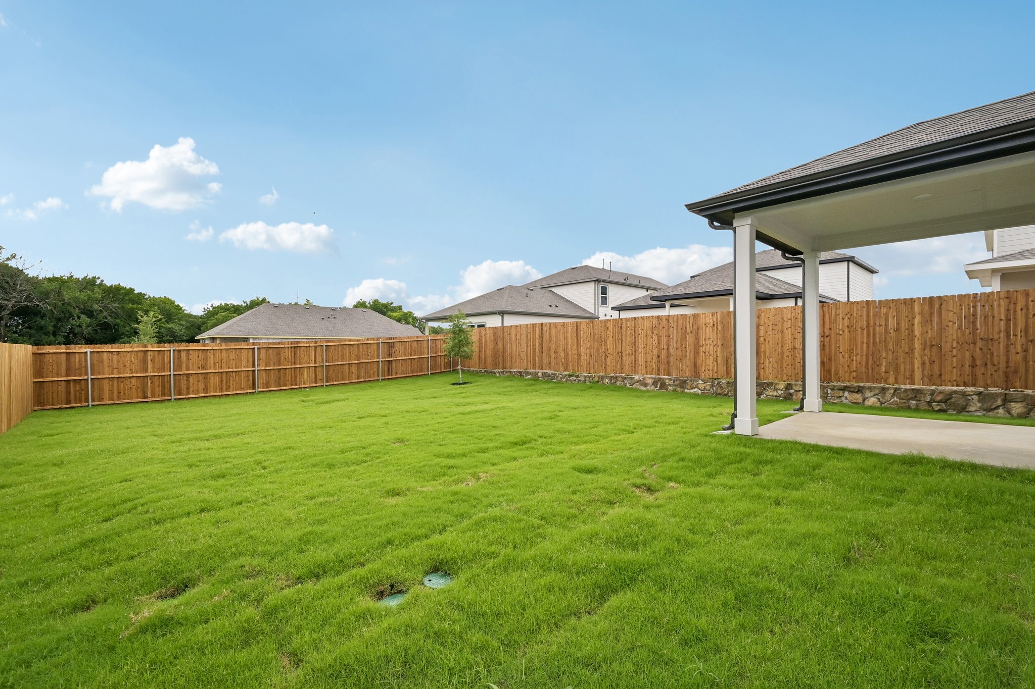 A fenced in yard with a building in the background.