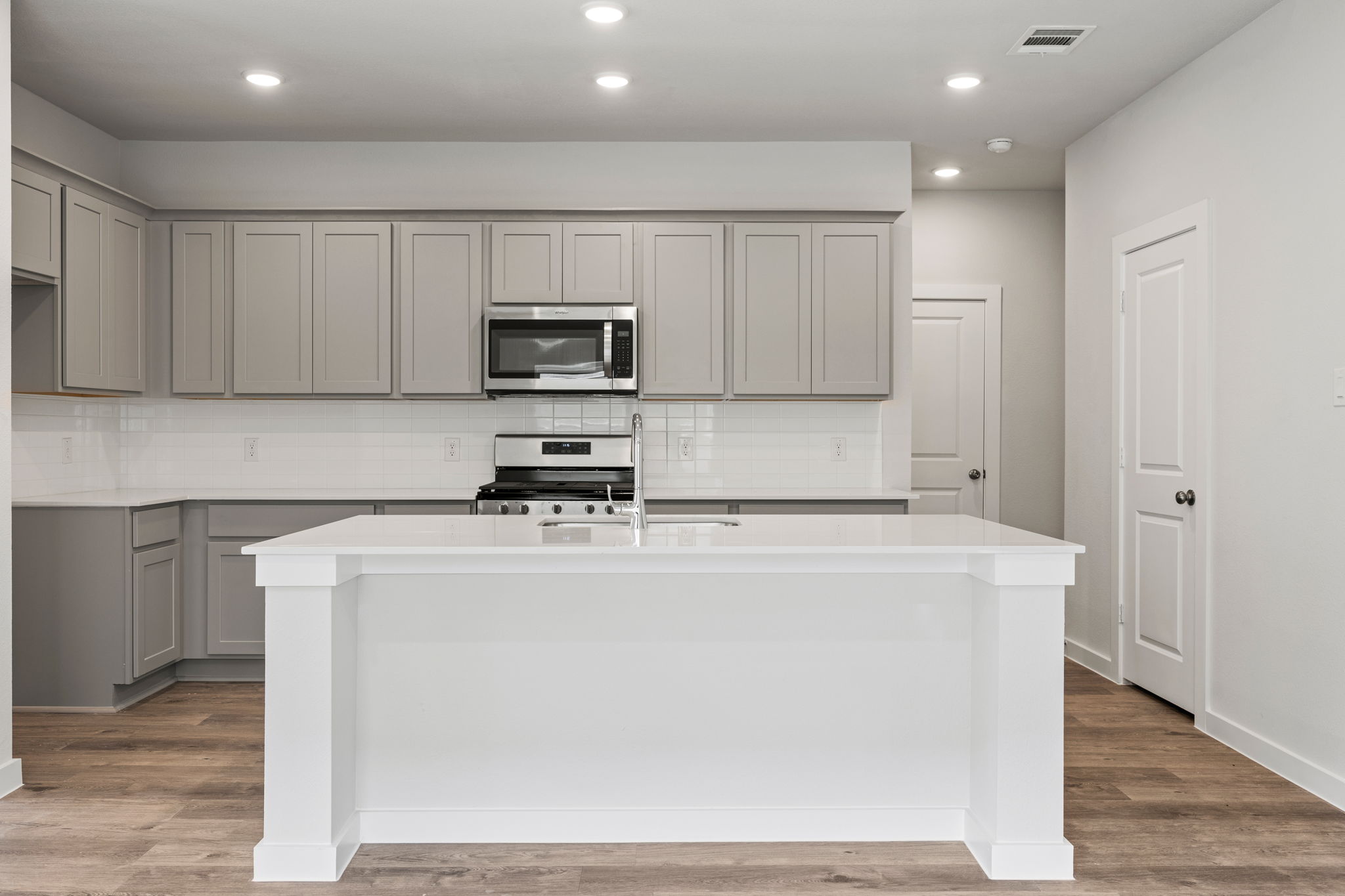 A kitchen with white cabinets.