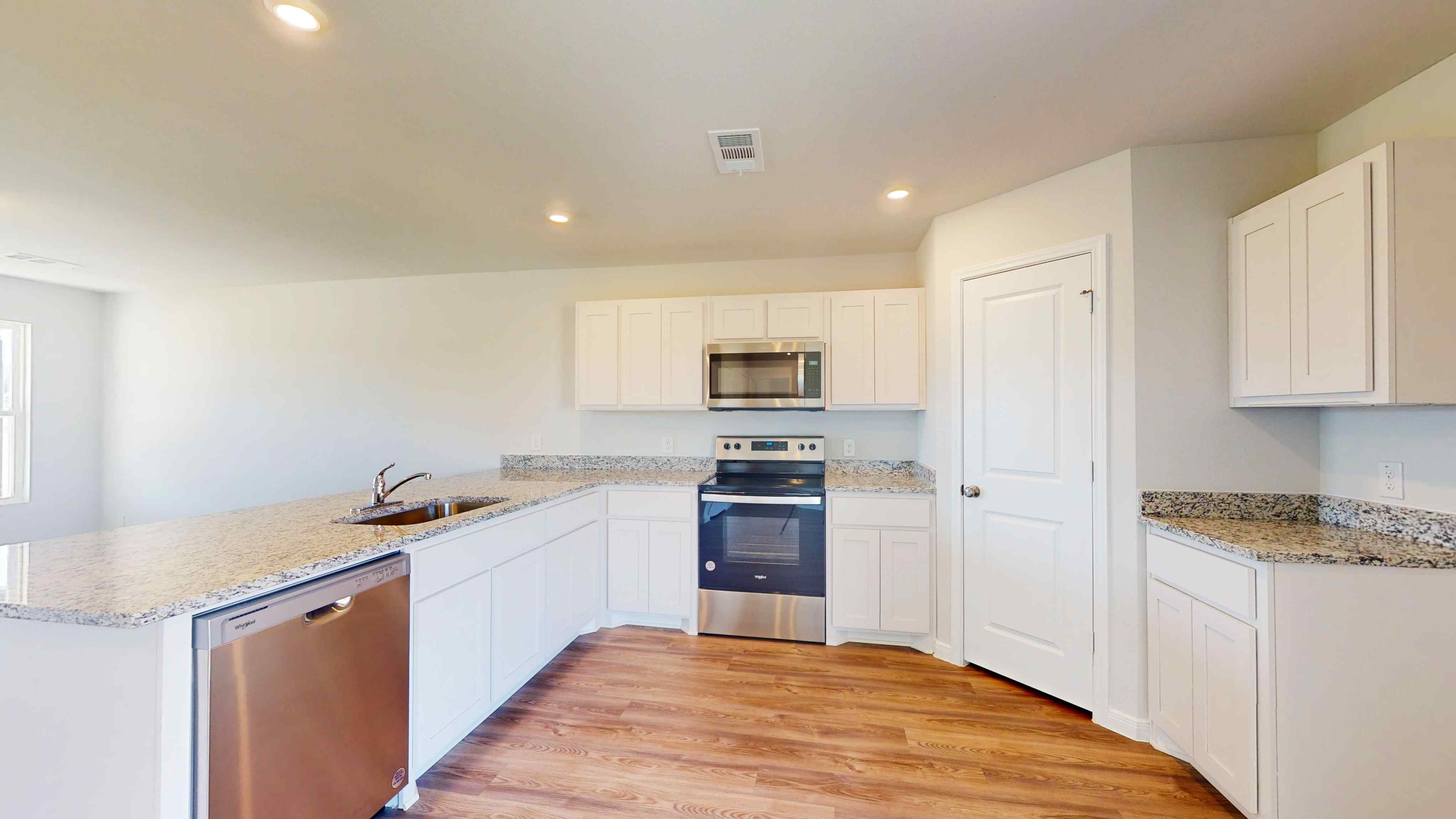 A kitchen with white cabinets.