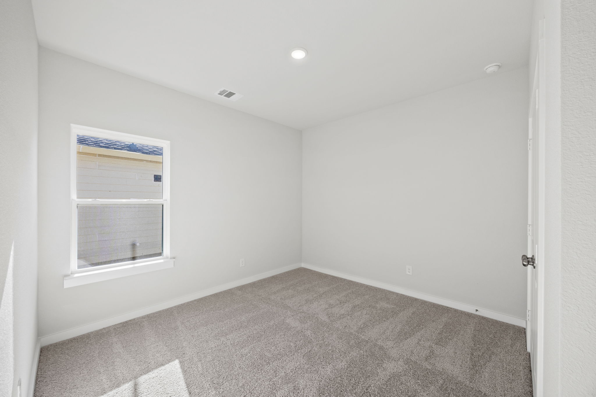 A room with a carpet and a window.