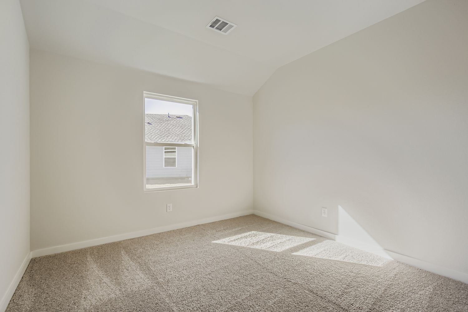 A room with a carpet and a window.