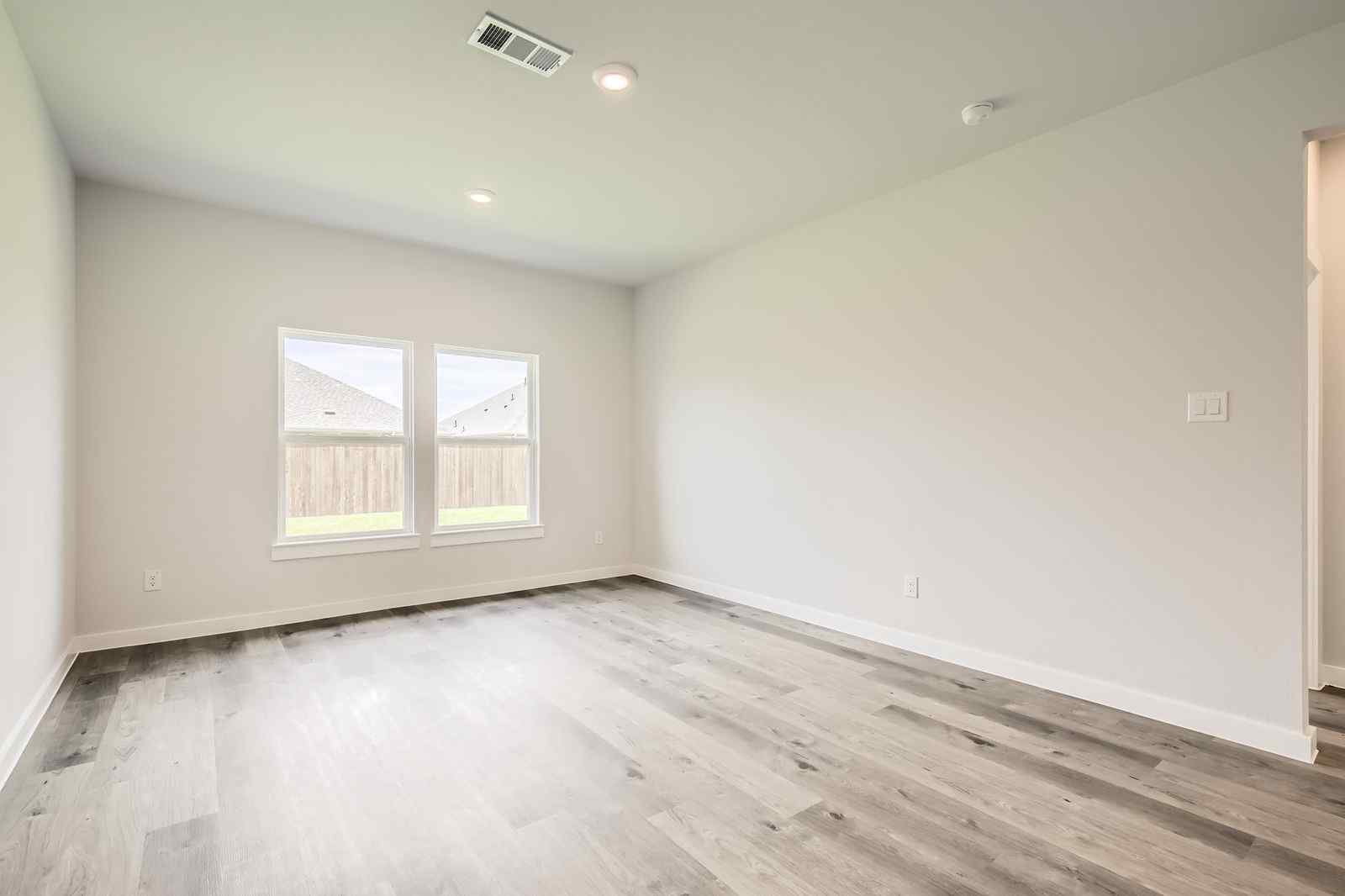 A room with a wood floor and a window.