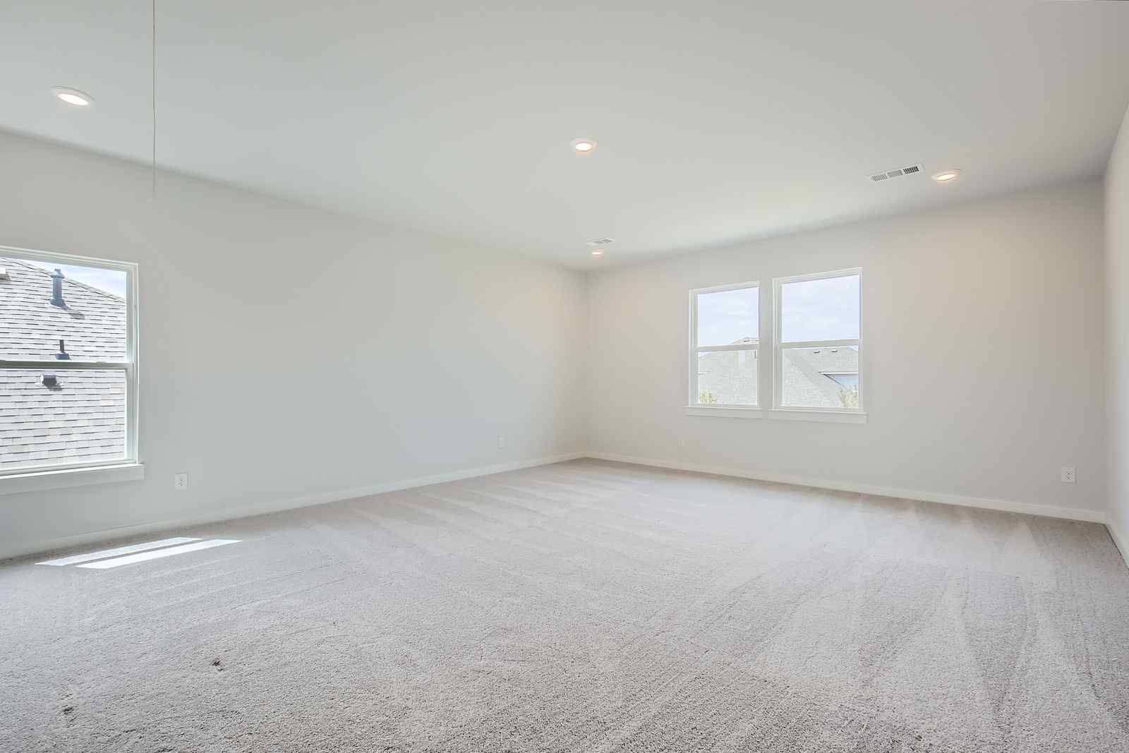 A room with a carpet and windows.