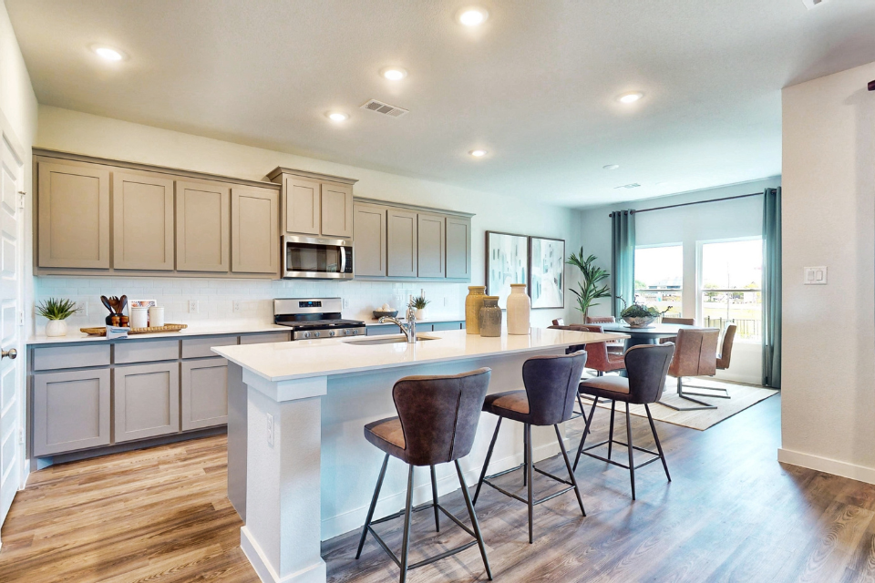 A kitchen with a dining table and chairs.