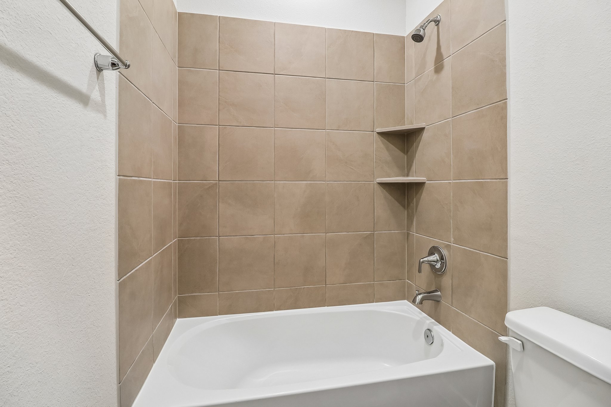 A bathroom with a bathtub and toilet.