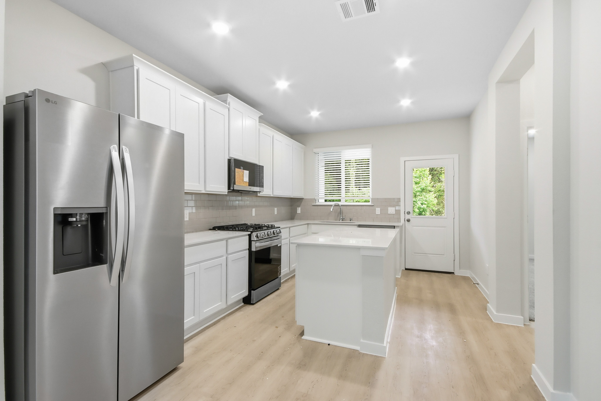A kitchen with white cabinets.