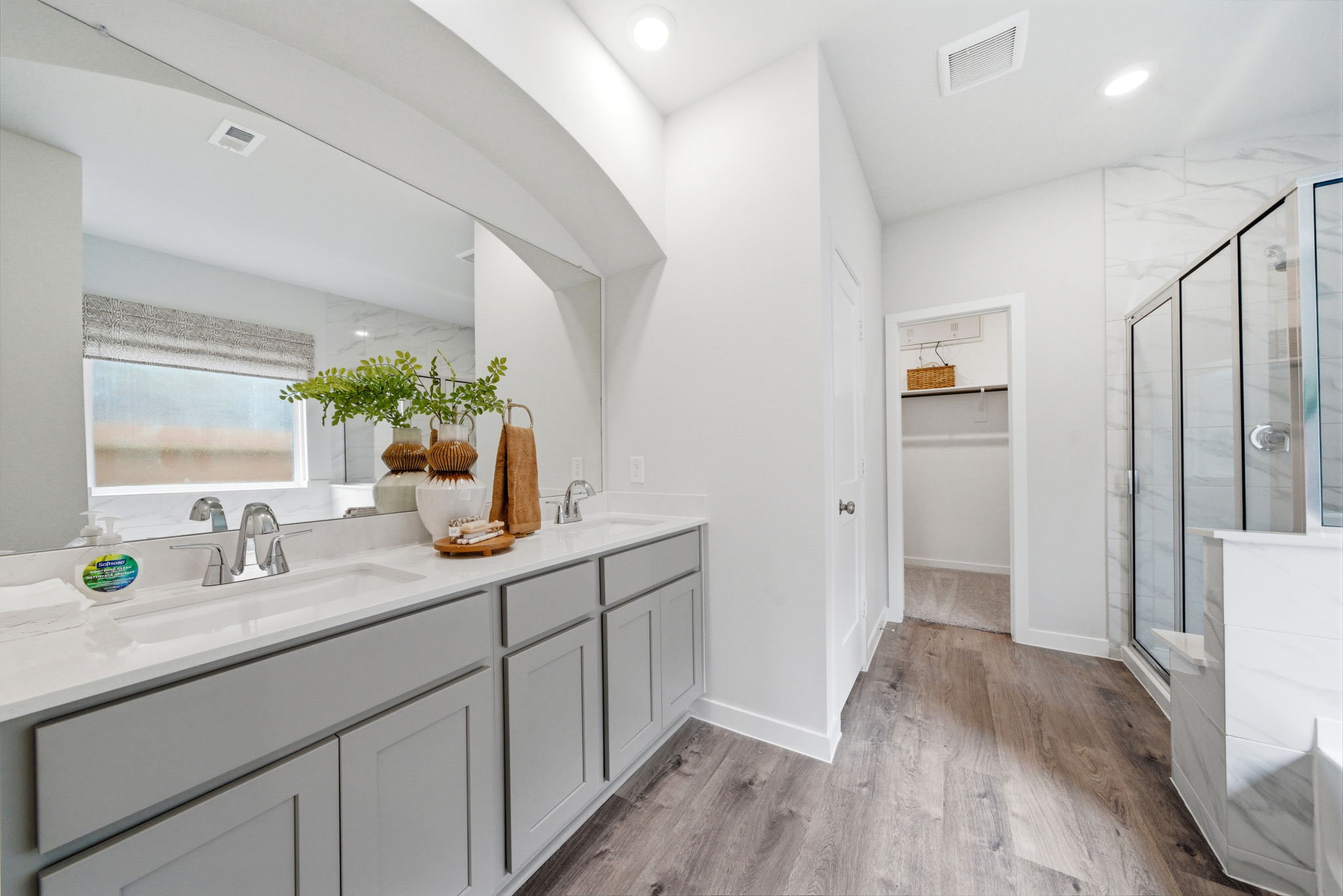 A bathroom with white cabinets.