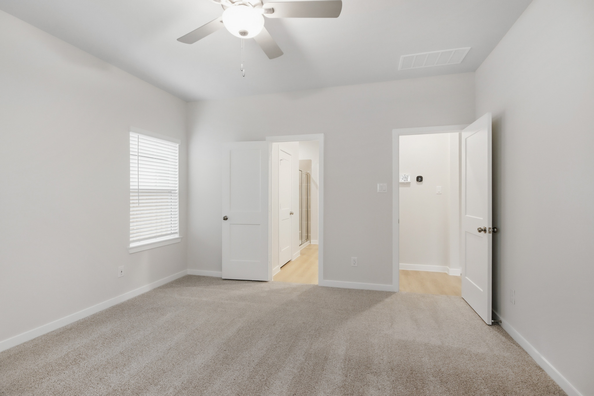 A room with white doors and a ceiling fan.