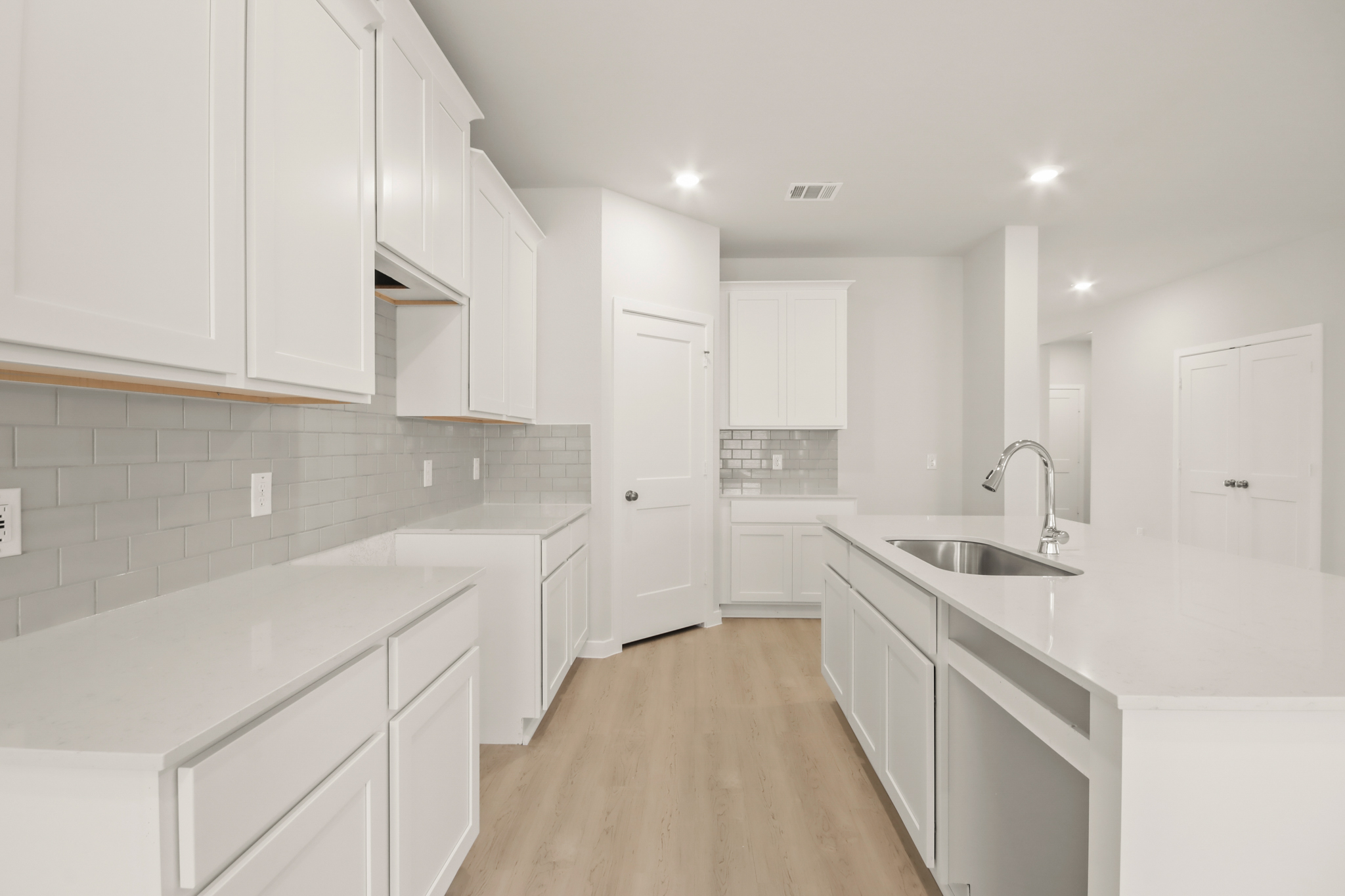 A kitchen with white cabinets.